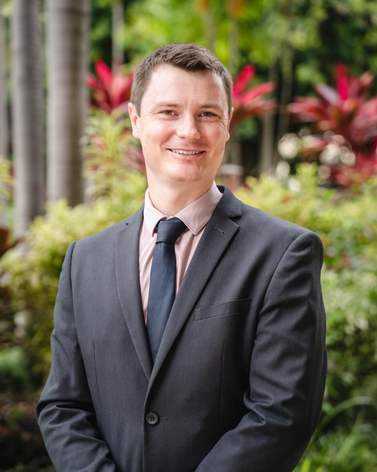 A Man in a Suit and Tie is Standing in Front of a Bush — SouthMac Finance In Townsville, QLD