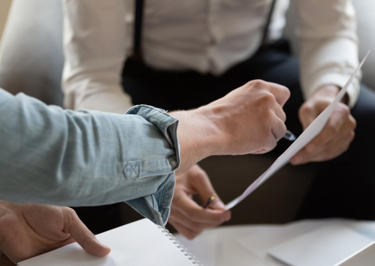 A Man and a Woman Are Sitting at a Table Looking at a Piece of Paper — SouthMac Finance In Townsville, QLD