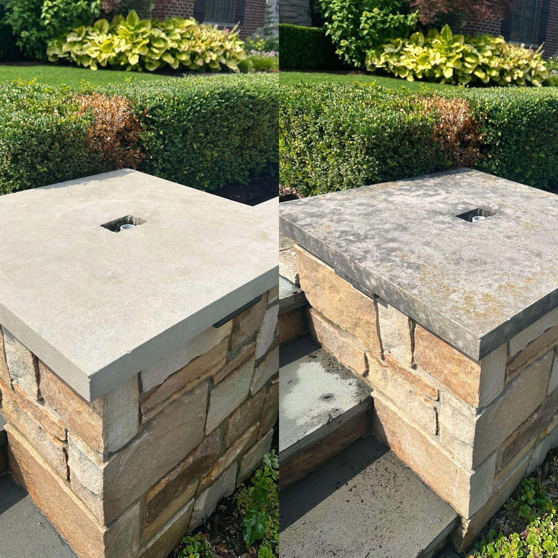 A person in a dark jacket and baseball cap uses a pole to pressure wash the beige vinyl siding of a house.