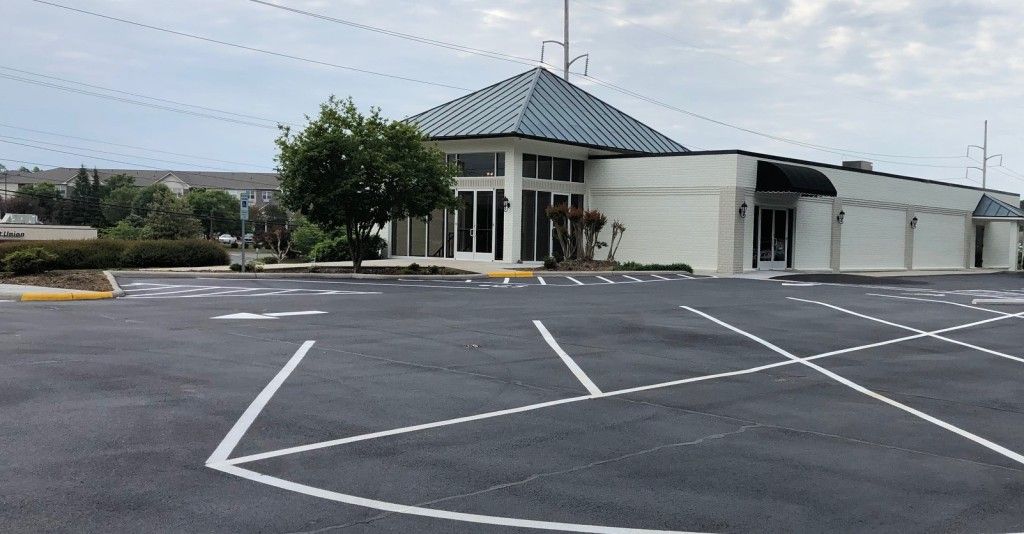 An empty parking lot with a building in the background