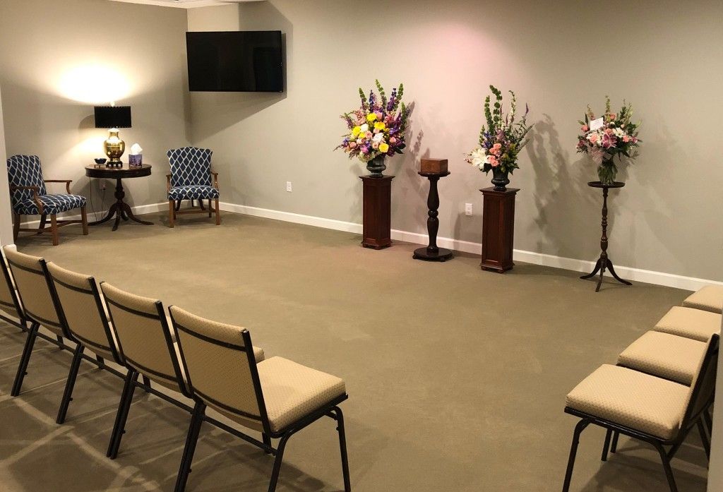 A room with a lot of chairs and flowers on the wall.