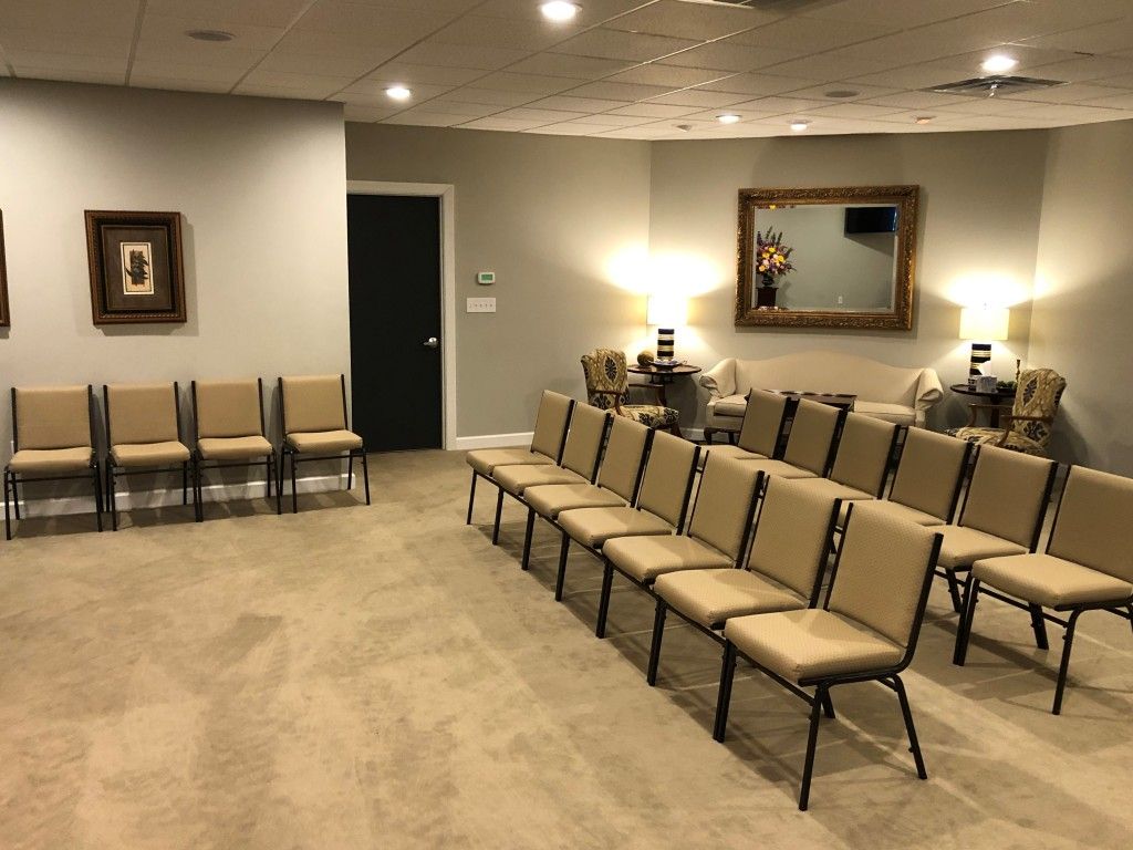 A room with a lot of chairs and a mirror on the wall.