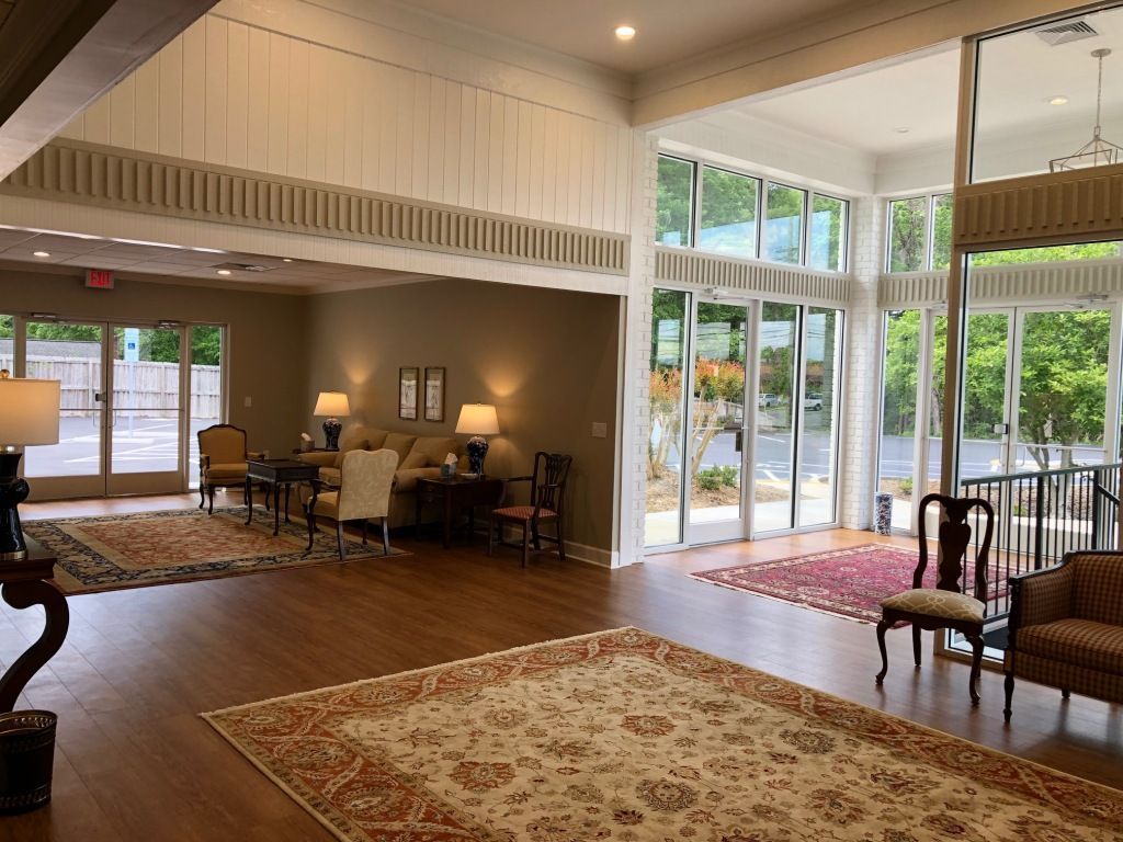 A large living room with a lot of windows and furniture.