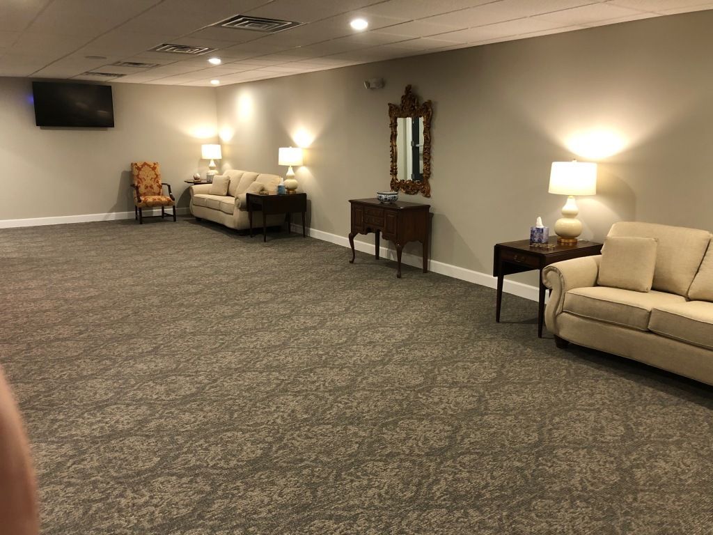 A living room with a couch , chair , table and television.