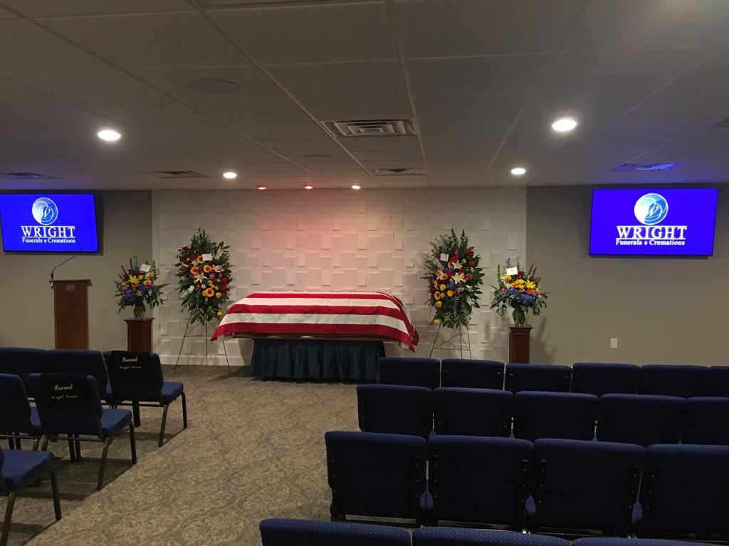 A funeral home with a coffin in the middle of the room.