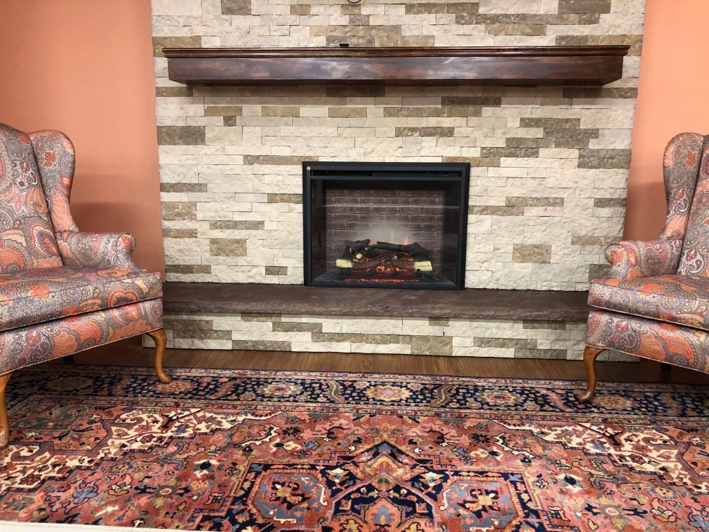 A living room with two chairs and a fireplace.