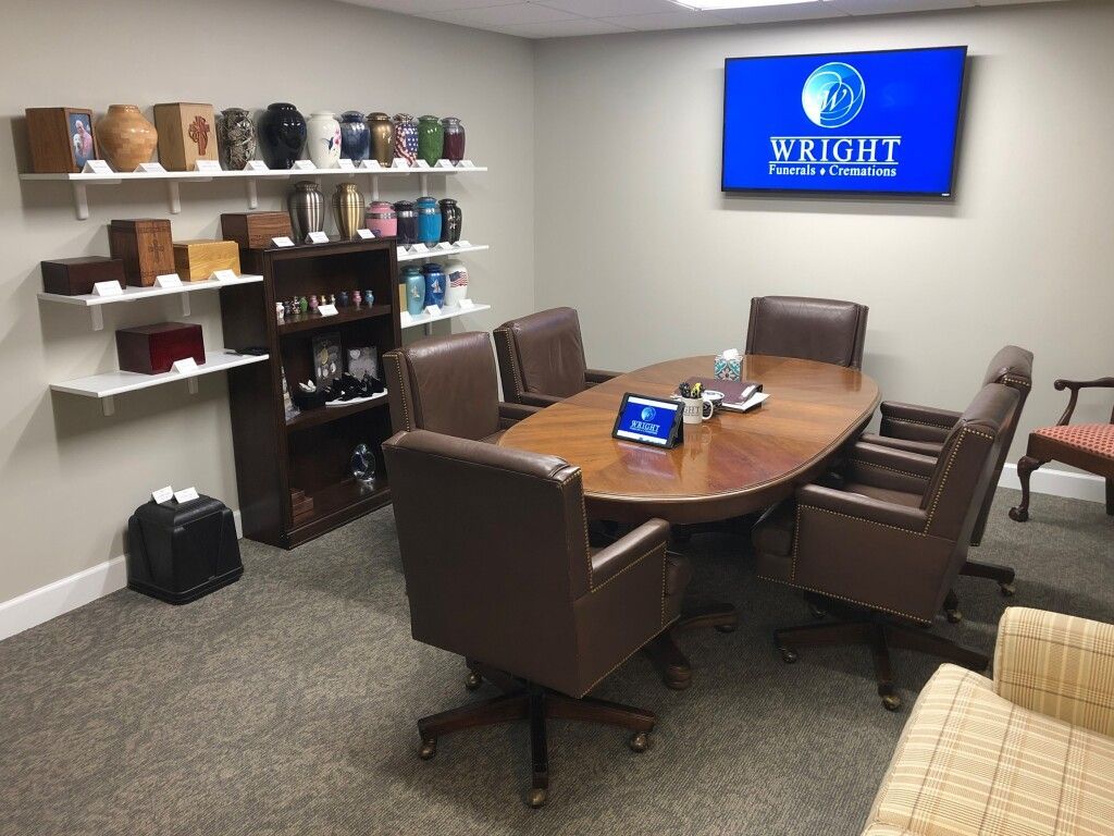 A conference room with a table and chairs and a tv on the wall.