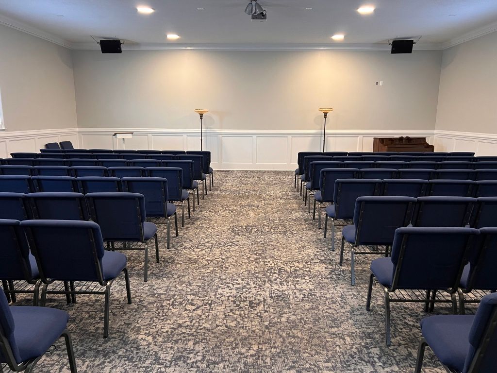 Rows of blue chairs are lined up in a church.