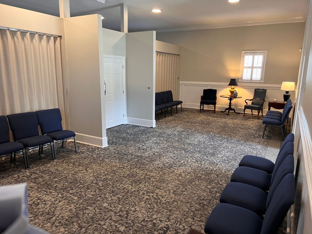 A waiting room with blue chairs and a window.