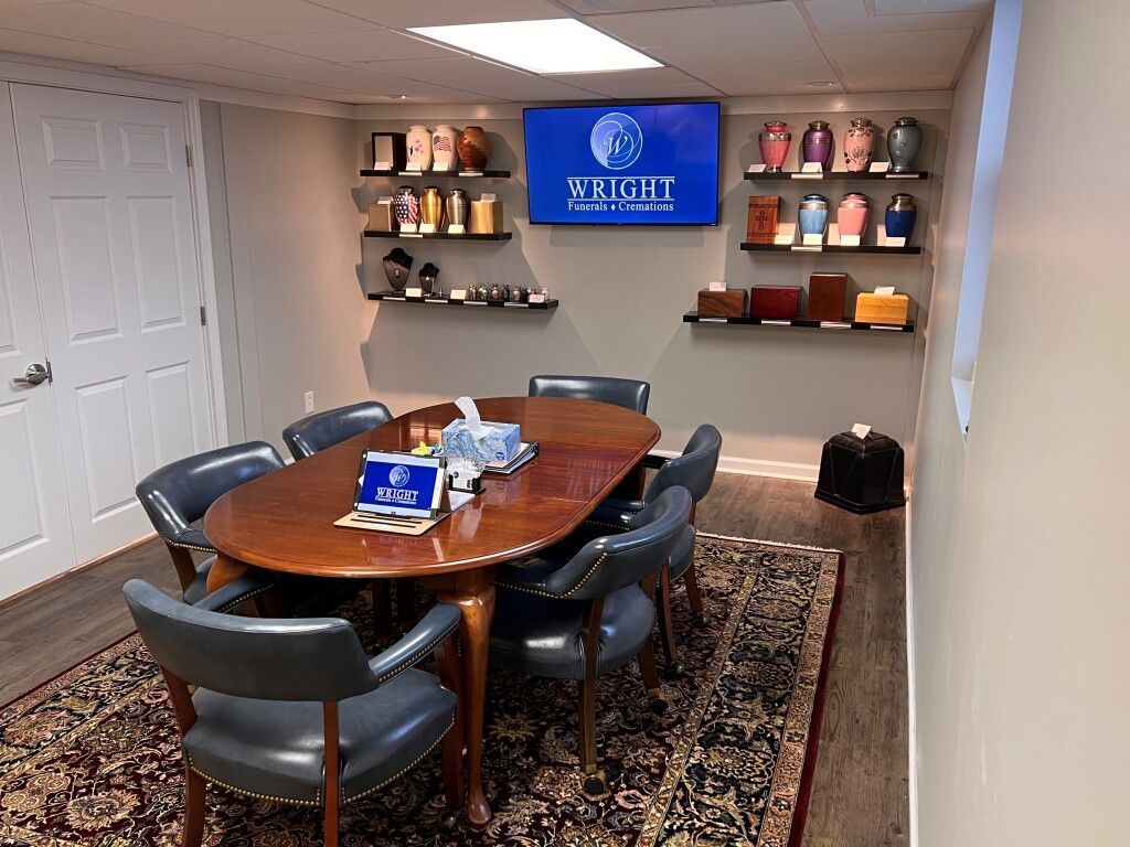 A conference room with a table and chairs and a television on the wall.