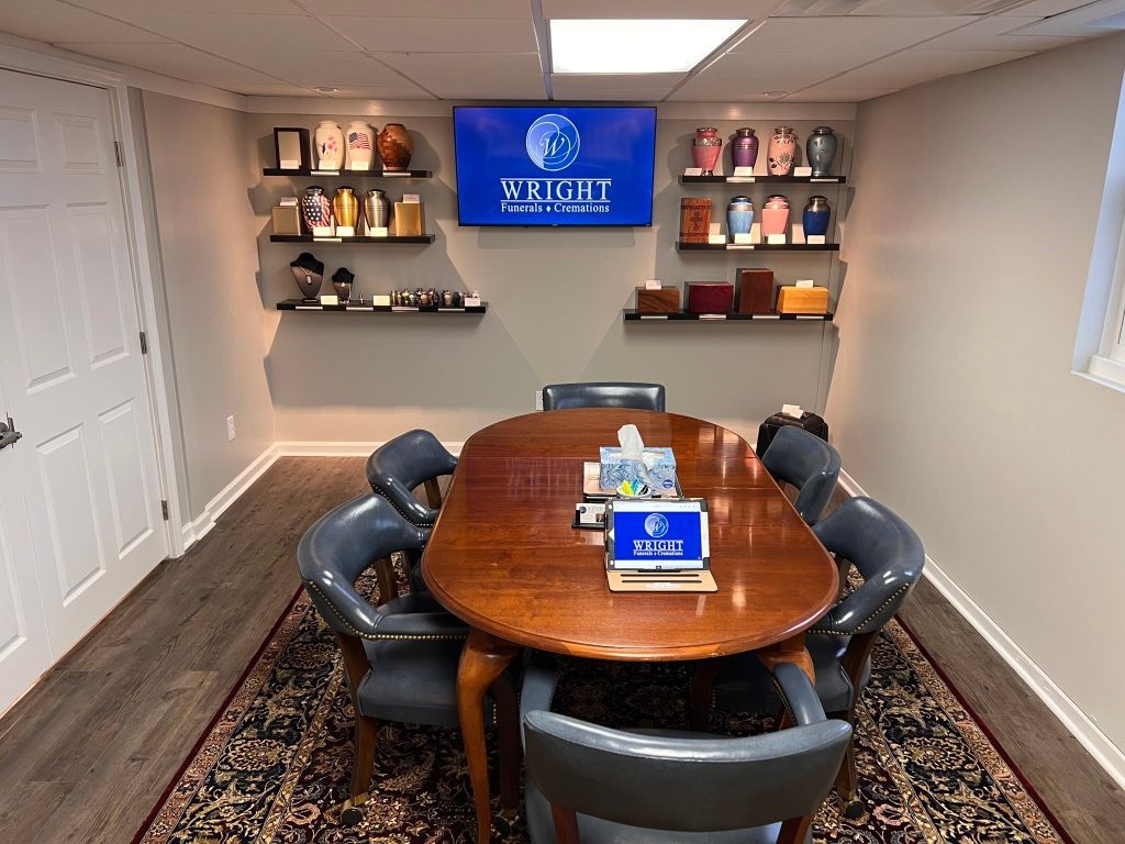 A conference room with a table and chairs and a television on the wall.