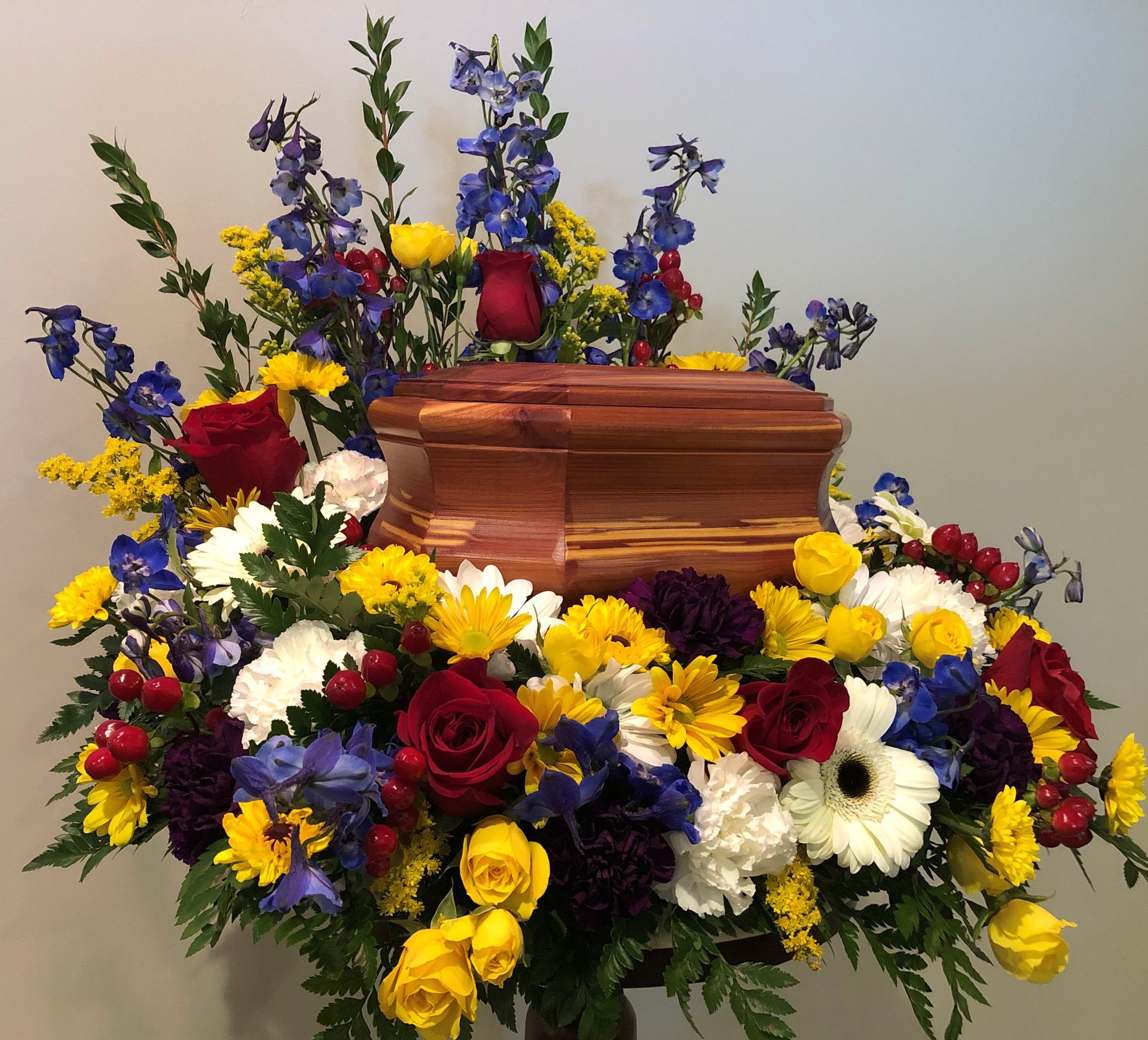 A white urn is surrounded by white flowers.