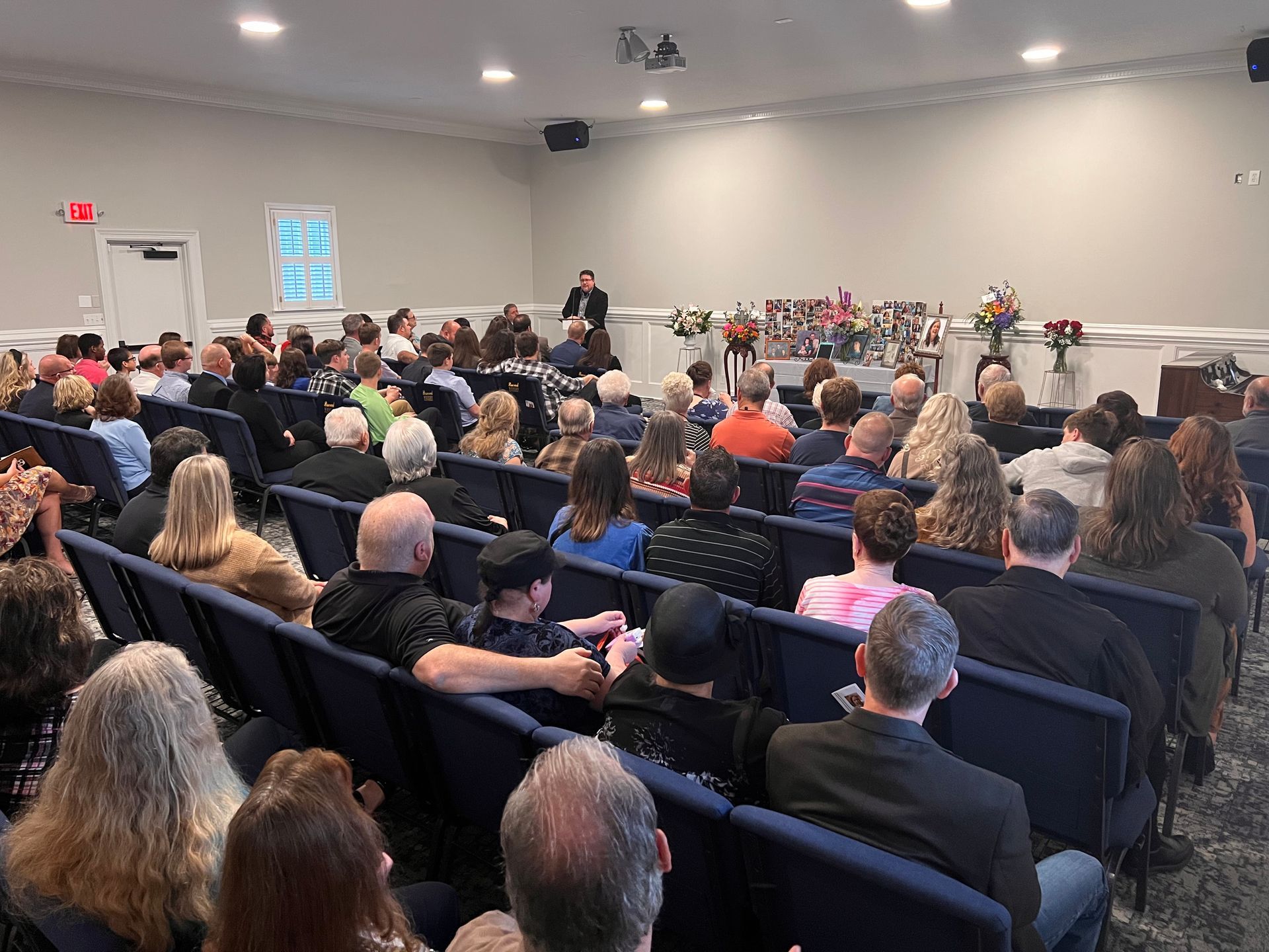 A small white house is sitting on the corner of a street.