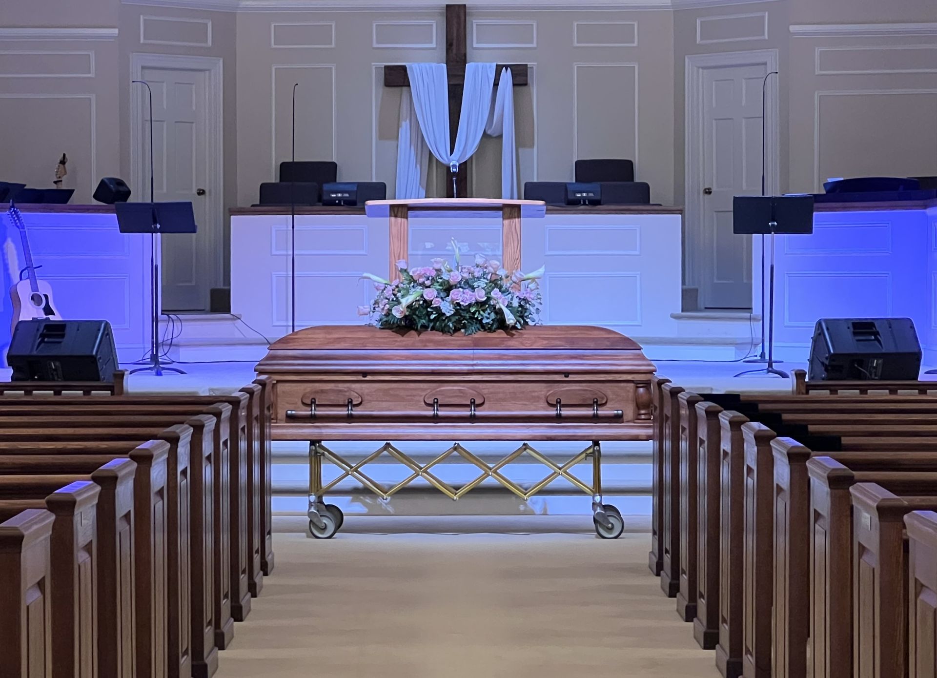 A group of people are sitting in a church in front of a coffin.
