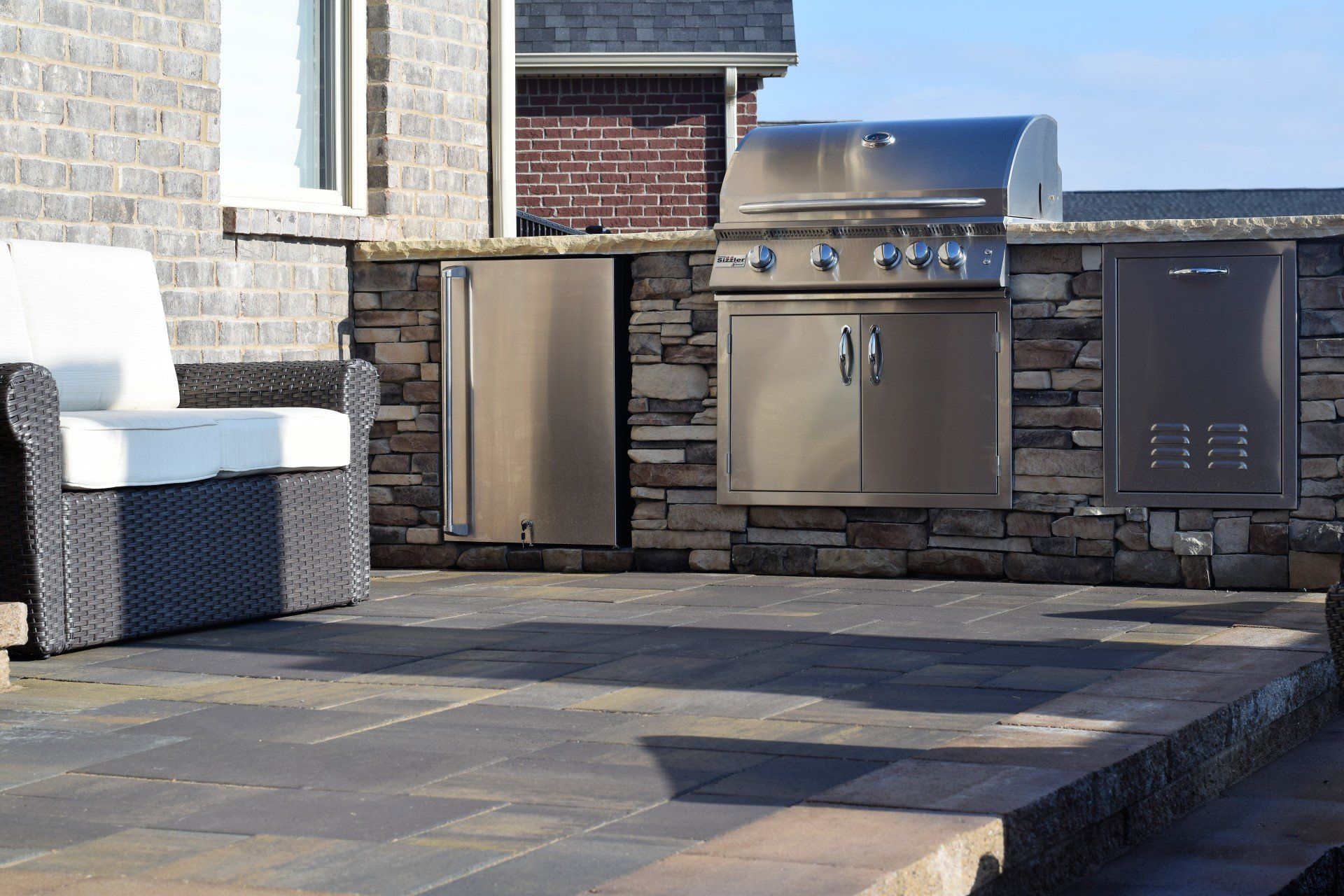 Outdoor stainless steal grill surrounded by stone counters