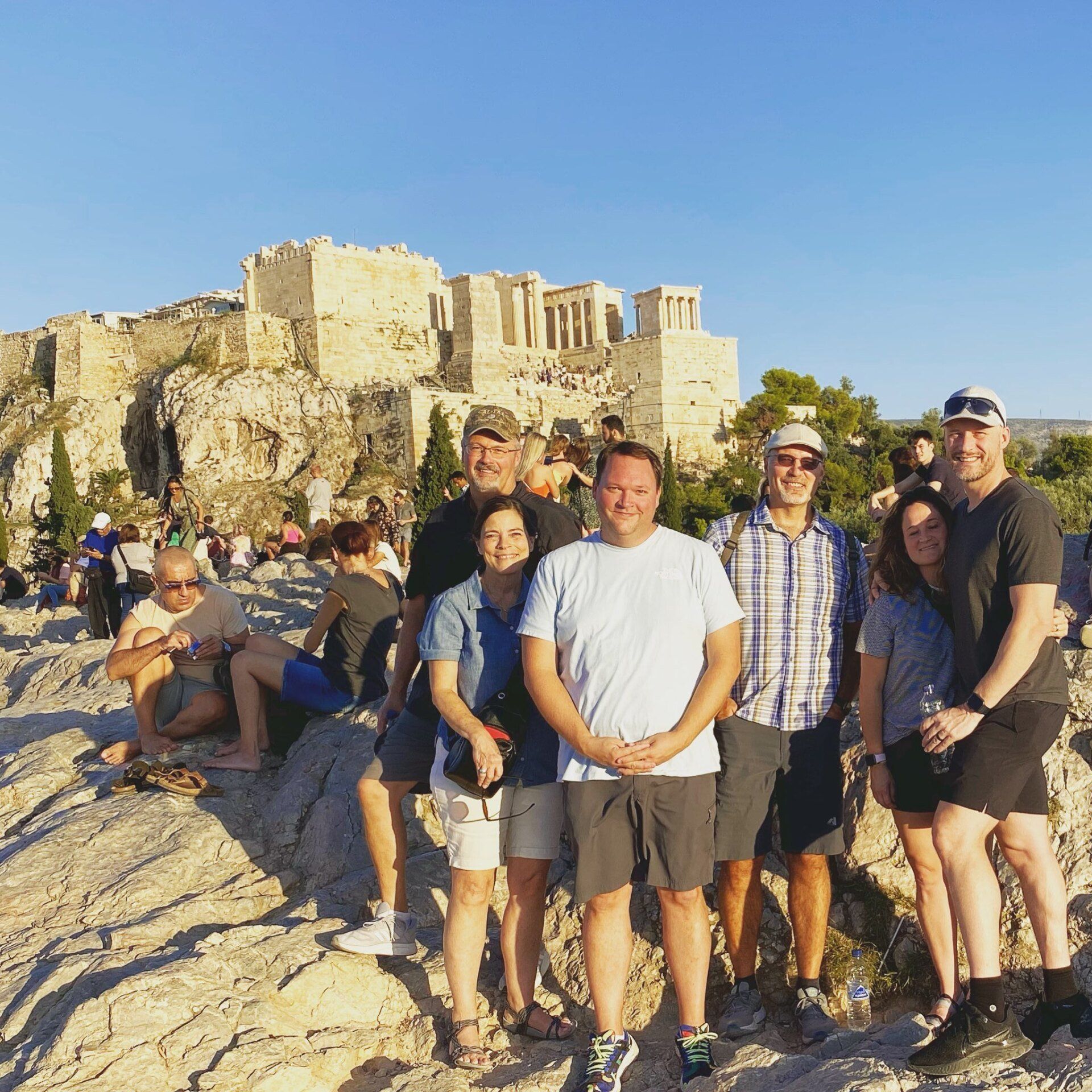 Mission team posing for a photo in front of the Acropolis in Athens, Greece, on a sunny day.