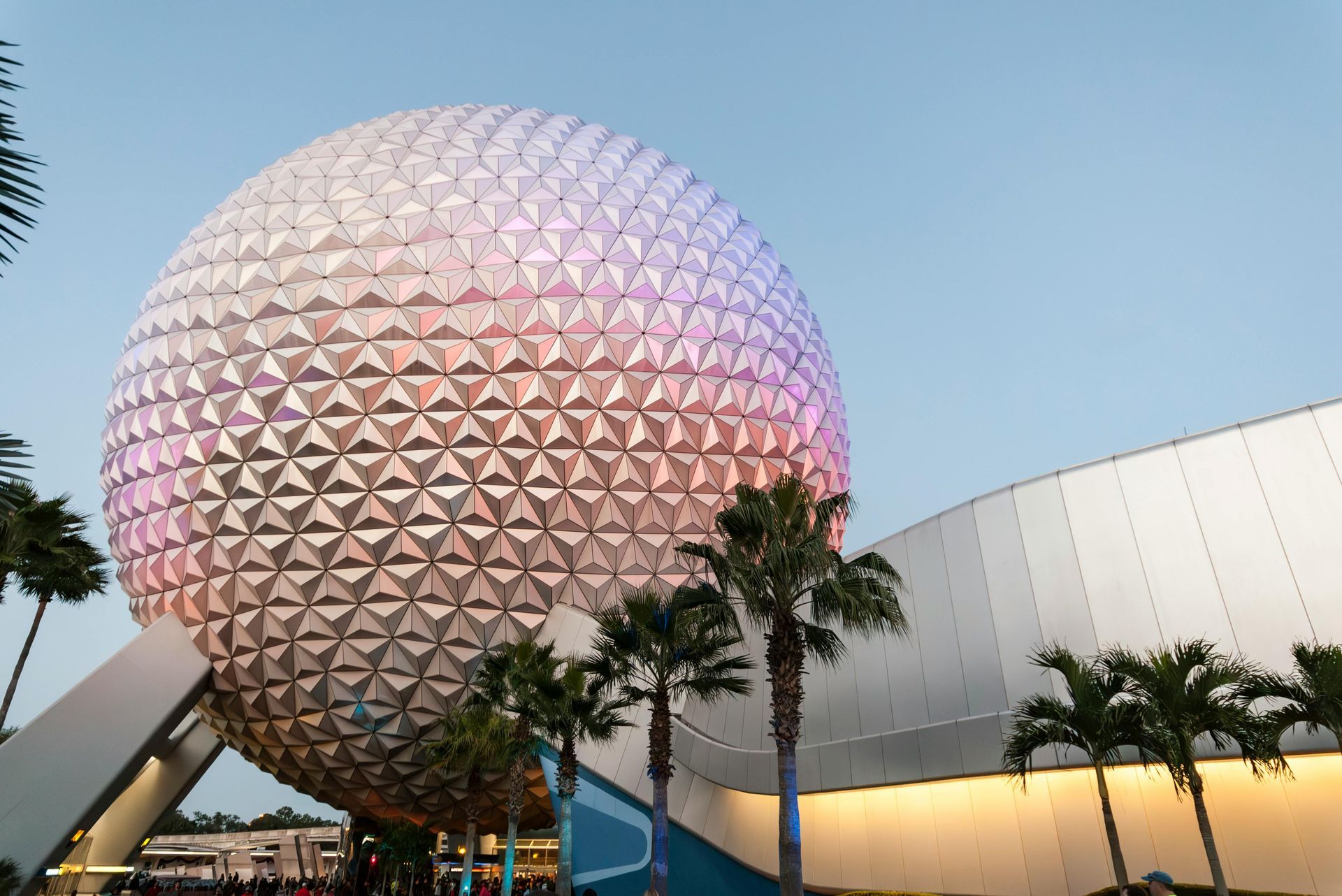 A large spherical building with palm trees in front of it.
