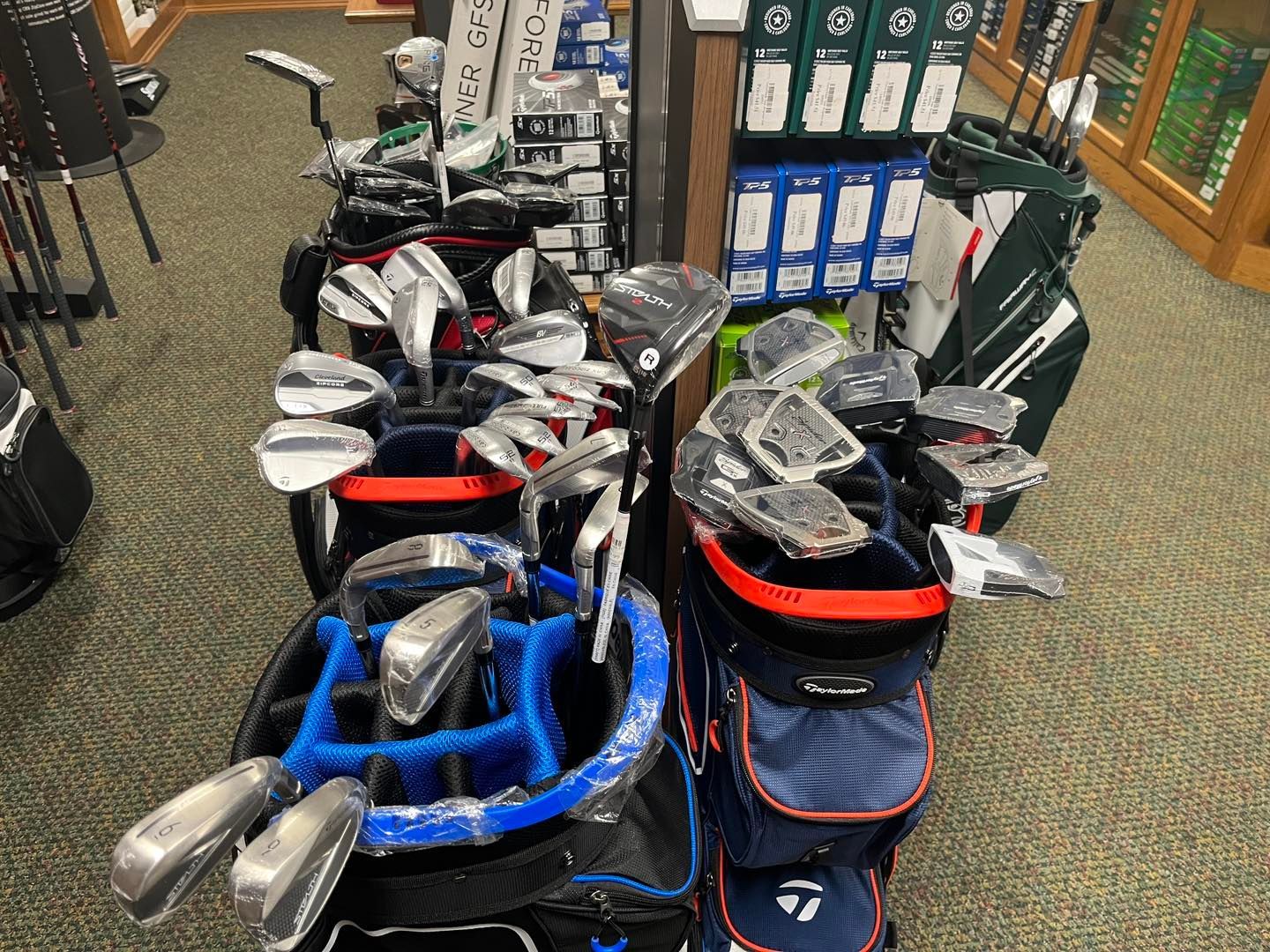 A display of golf clubs and bags in a store.
