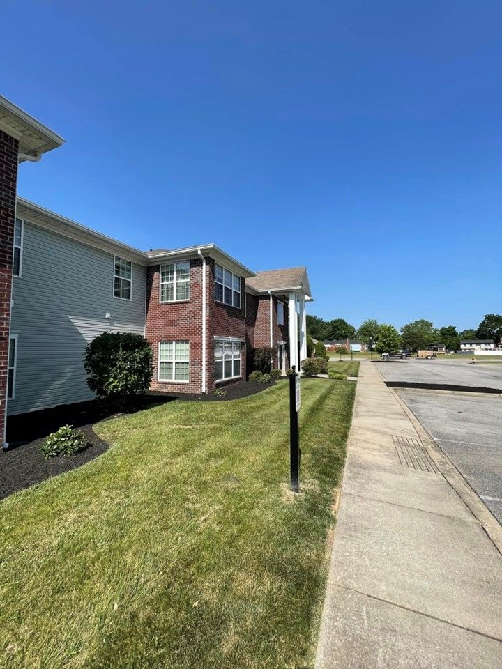 A brick apartment building with a lush green lawn and a sidewalk in front of it – Mt. Washington, KY - Beck’s