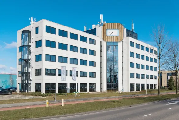 Kantoorgebouw met witte gevel, klokkentoren en blauwe lucht. clockhouse