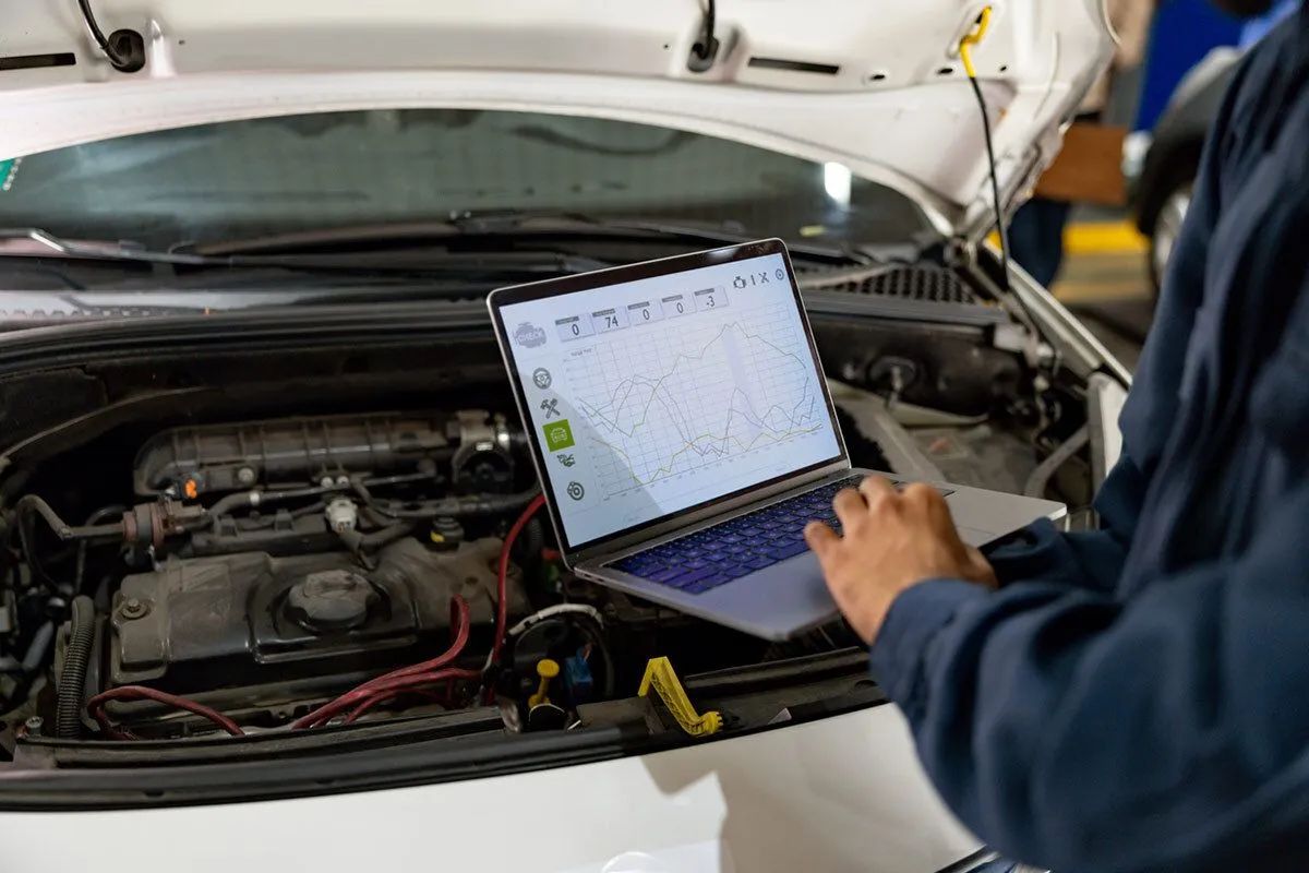 Mechanic checking vehicle diagnostics on a laptop
