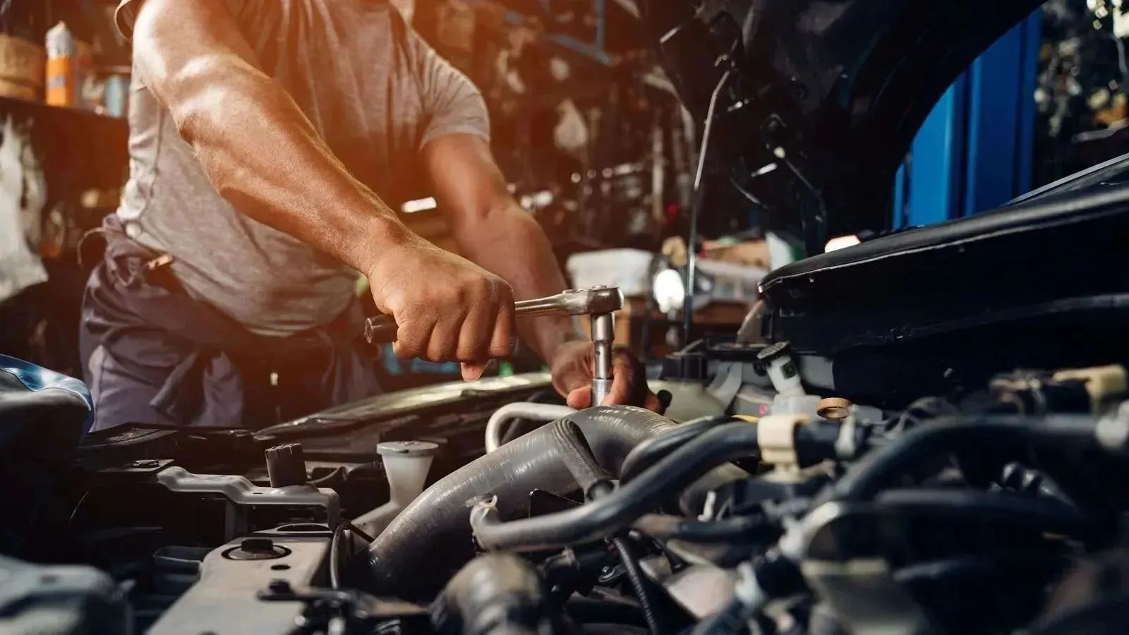 Mechanic using a wrench to tighten engine components during professional car servicing