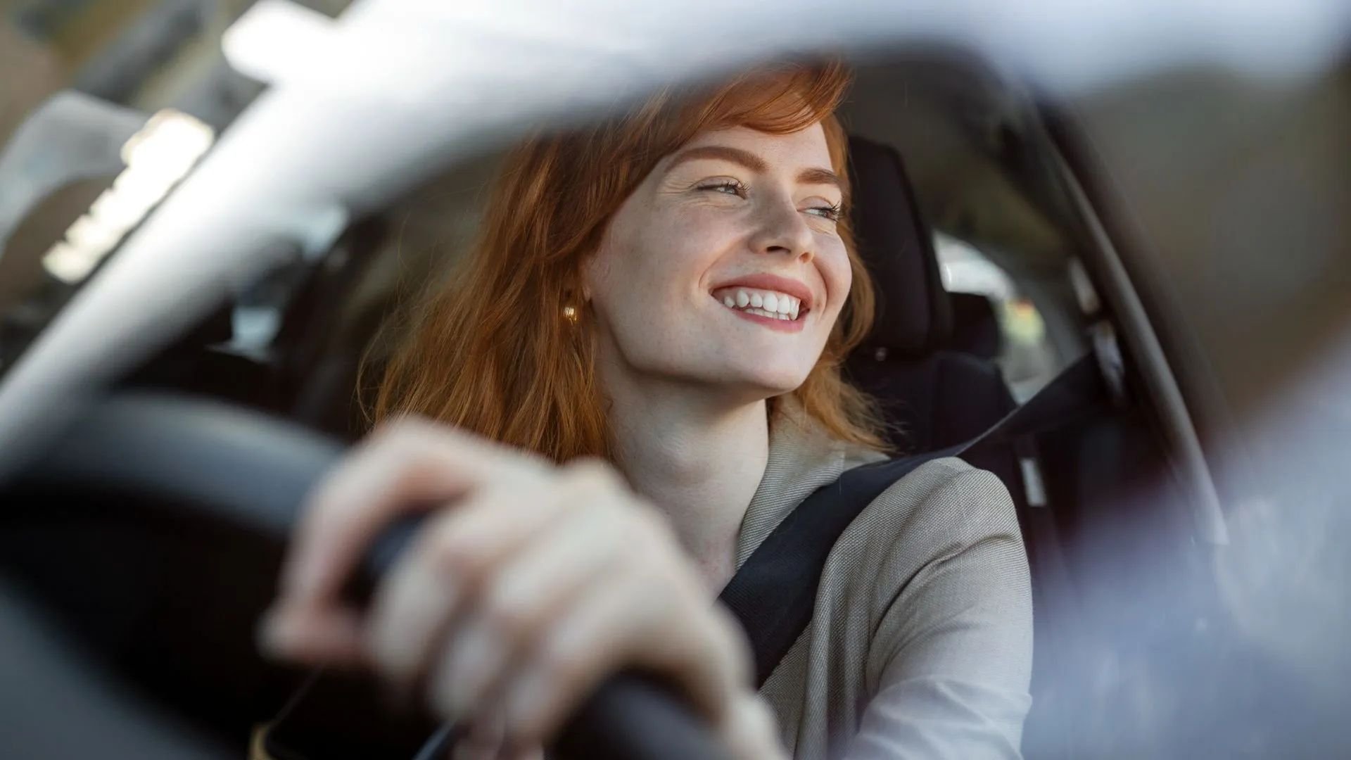 Person driving a car, looking out of the window
