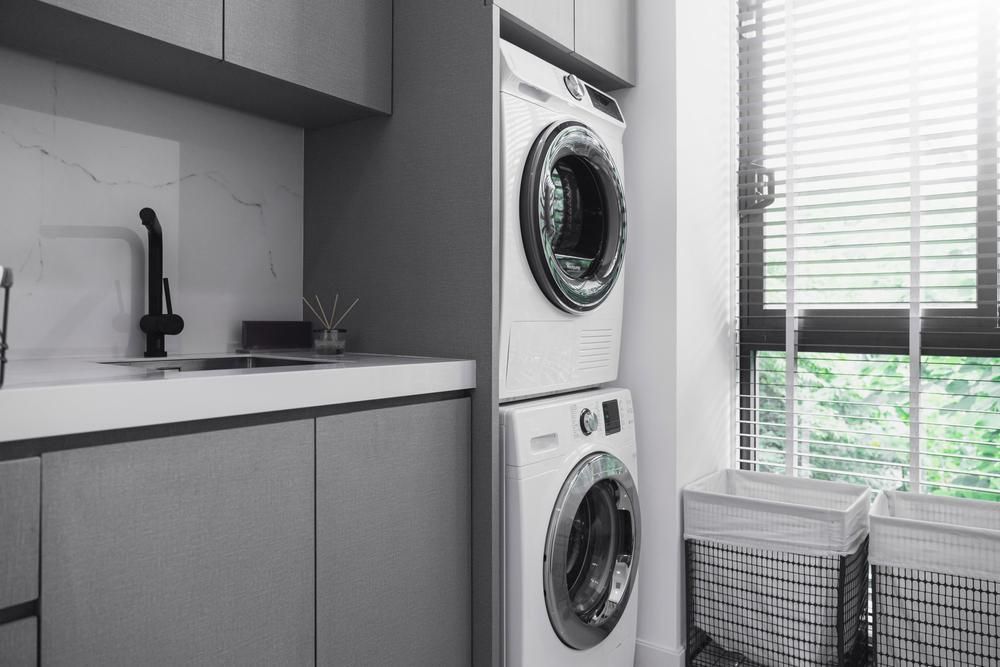 Laundry Room With Stacked Washer And Dryer Next To Window With Venetian Blinds — BC Customs in Central Coast, NSW