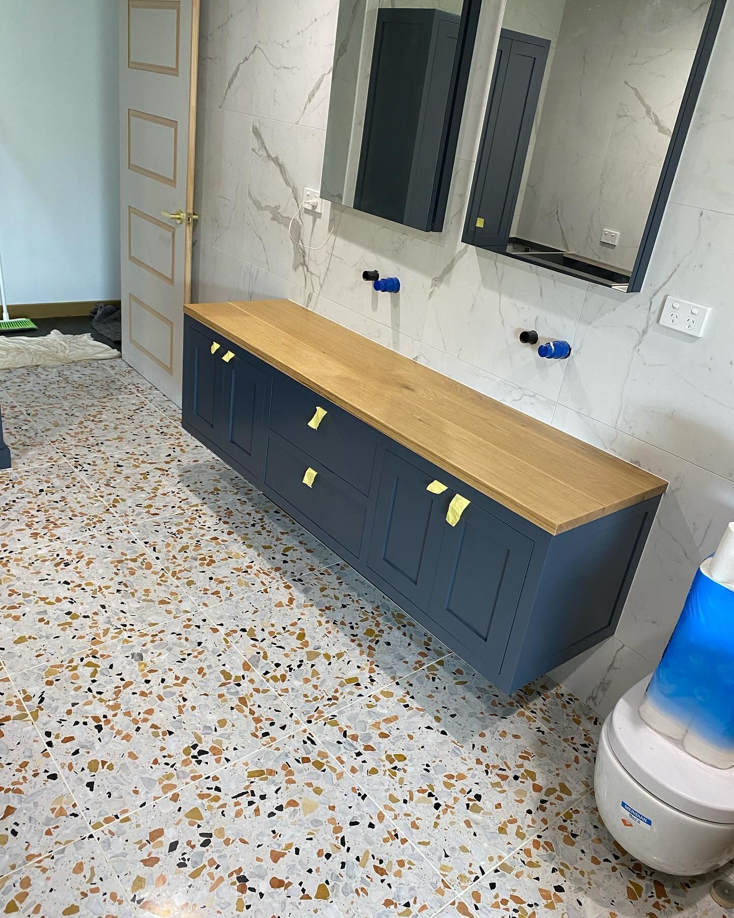Floating blue bathroom cabinet with a light wood countertop — BC Customs in Burrell Creek, NSW