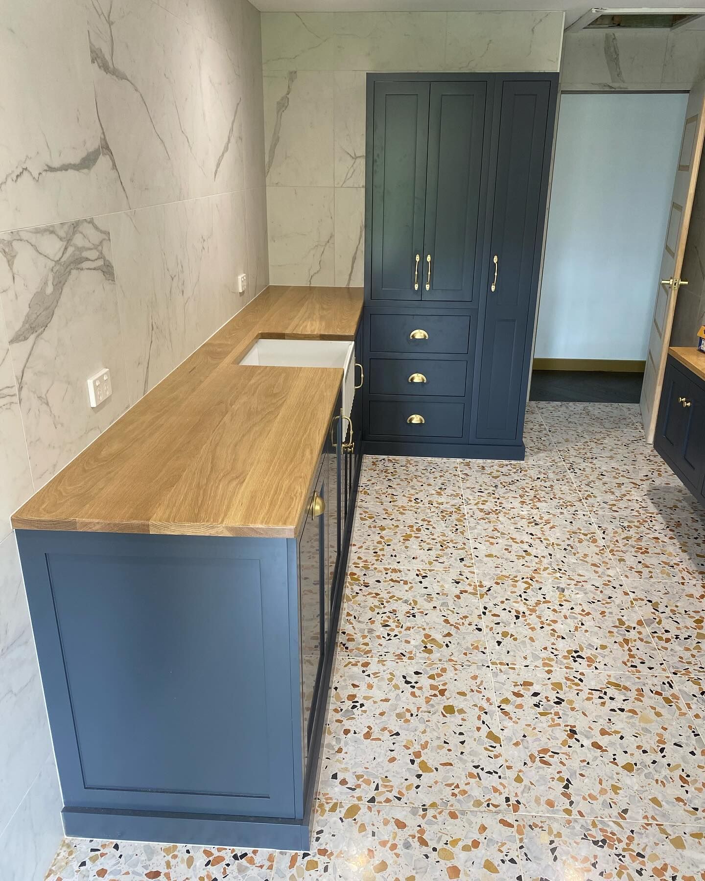Kitchen with blue cabinets, wood countertop, and terrazzo floor — BC Customs in Burrell Creek, NSW