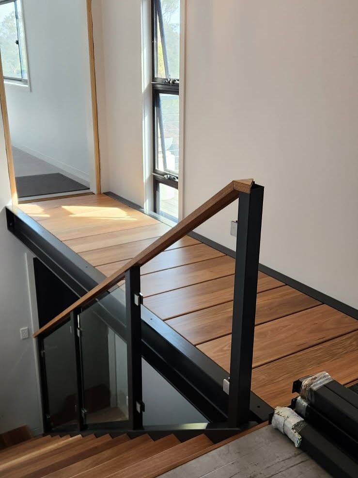 Wooden walkway with glass and black metal railing, overlooking a staircase — BC Customs in Burrell Creek, NSW