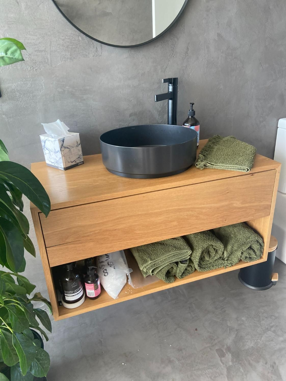 Wooden Vanity With Dark Sink, Towels, Toiletries, And Tissue Box Against Gray Wall — BC Customs in Central Coast, NSW
