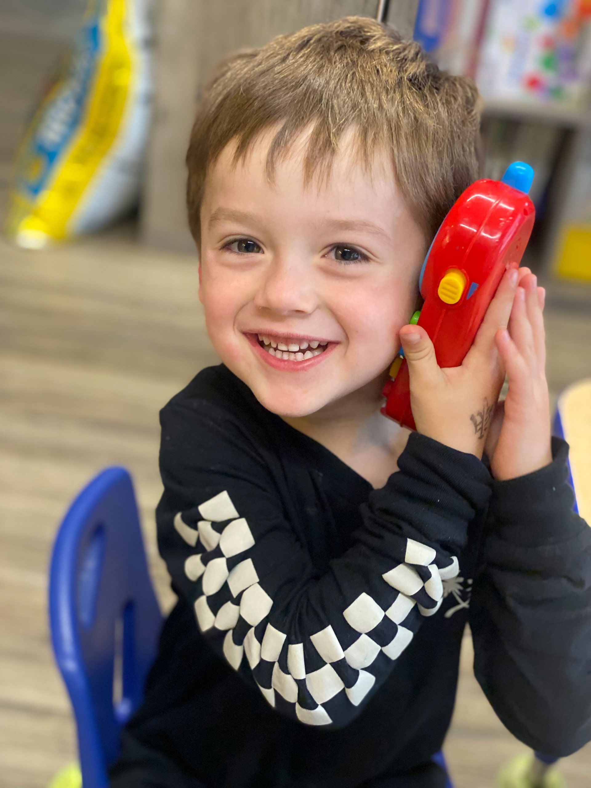 Young Boy is Holding a Toy Phone – Oroville, CA – Aunt Sherrie's Preschool