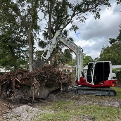 A large pile of roots is being removed from a tree by an excavator.
