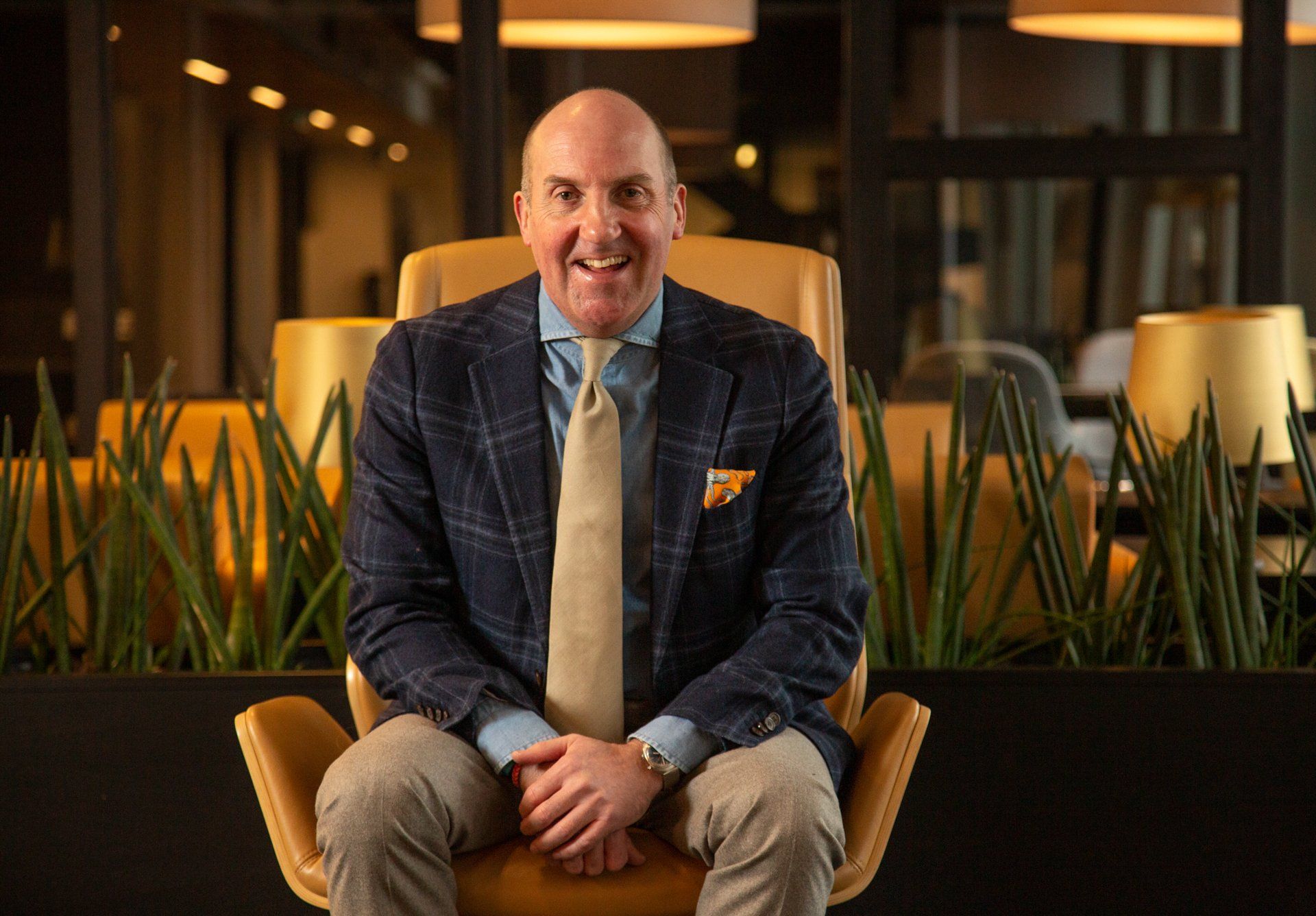 A man in a suit and tie is sitting in a chair.