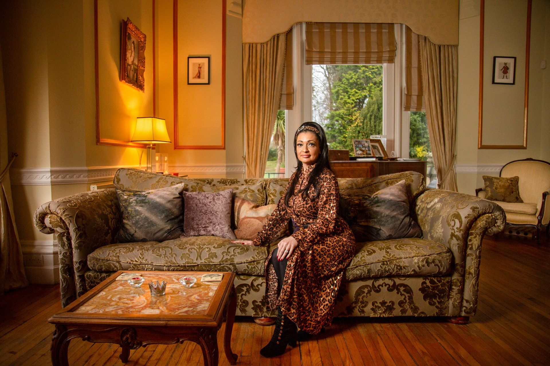 Portrait photography of lady wearing long leopard print coat in estate lounge, Leeds