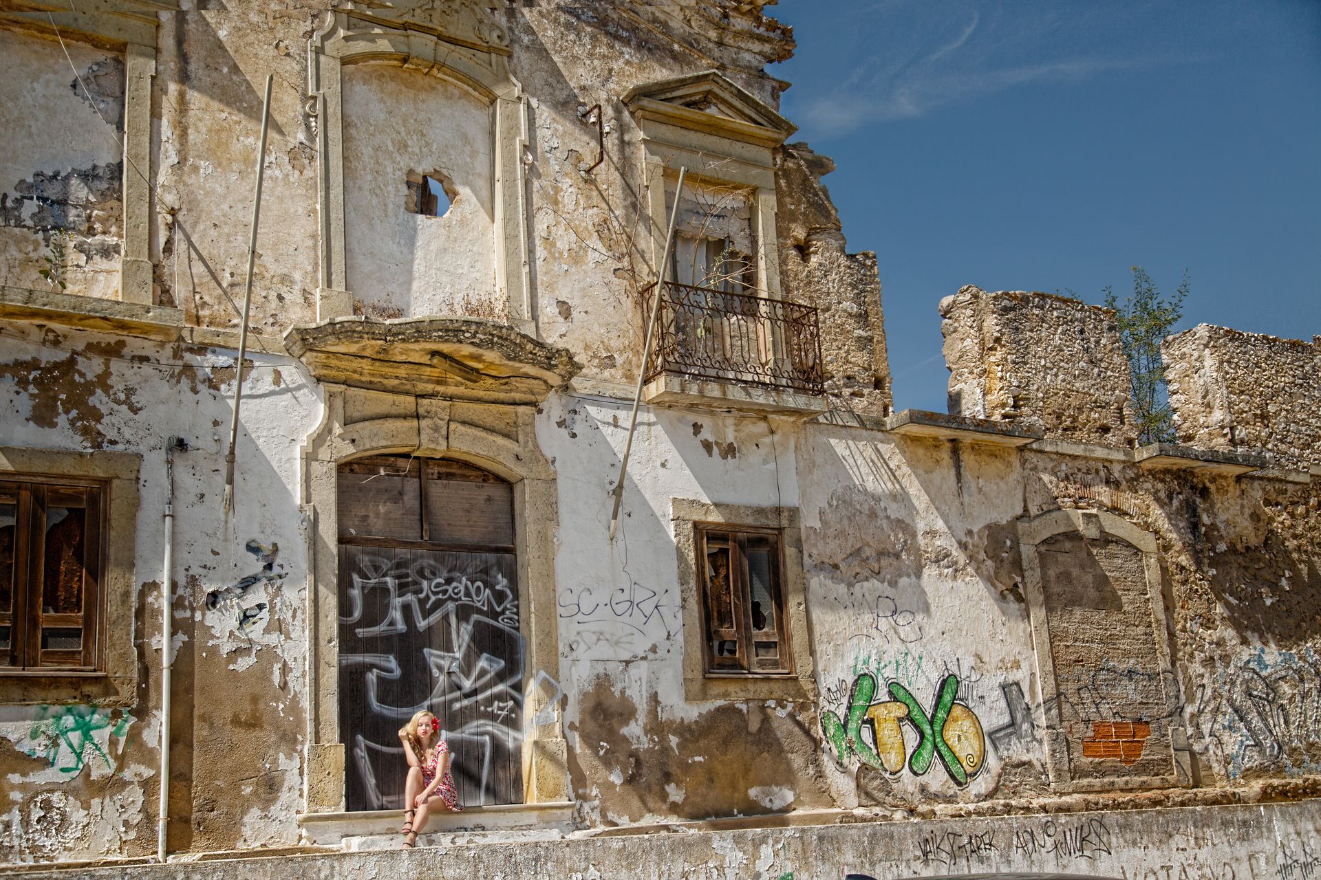 Model photoshoot Algarve girl posed in front of derelict building.