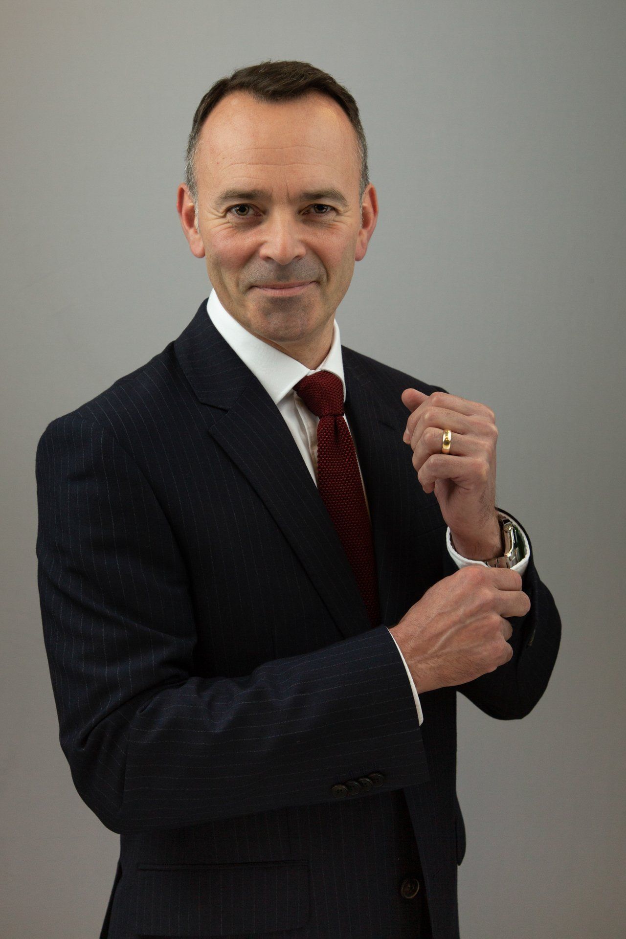 Corporate headshot in Leeds studio of a man holding cufflink