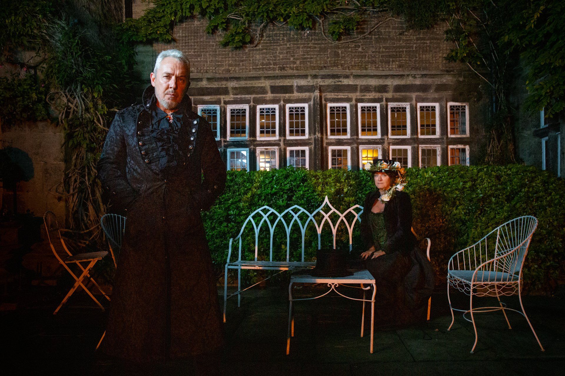 Night time portrait photography of gothic couple seated outside Holdsworth House, Halifax