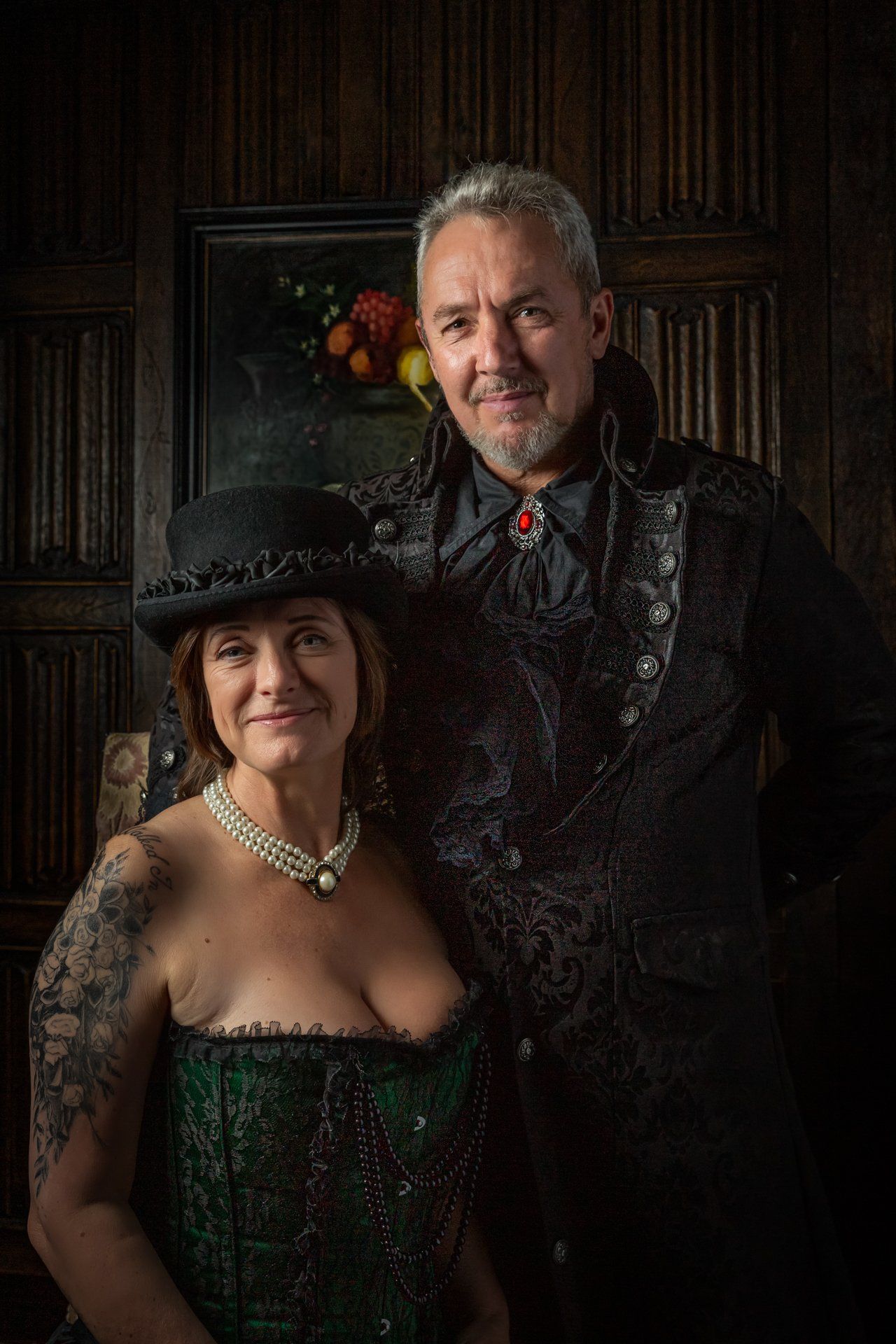 Beautifully lit portrait of gothic couple seated inside Holdsworth House, Halifax