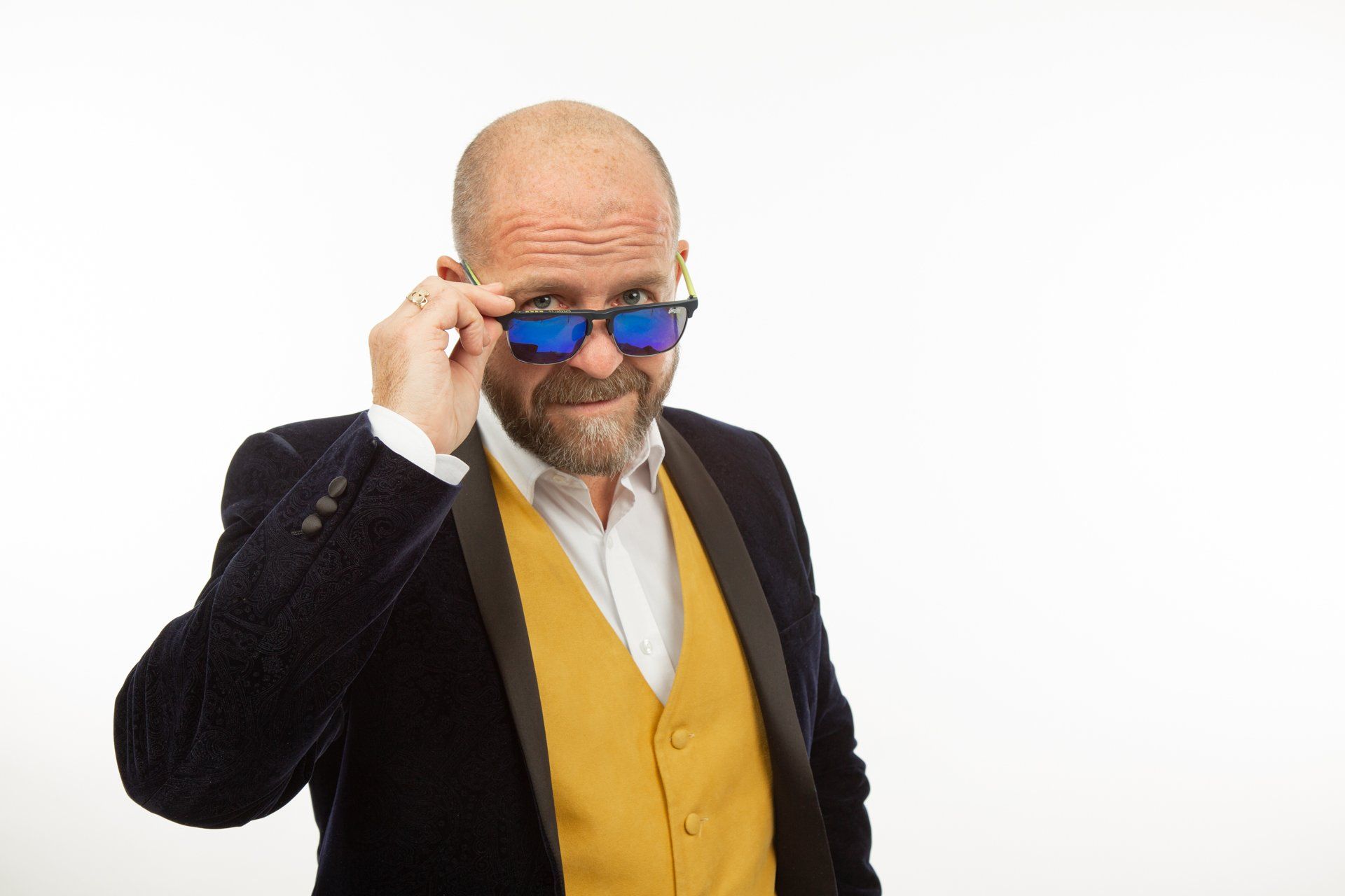 Emotipic of man wearing yellow waistcoat looking over blue sunglasses taken in Leeds Photography Studio