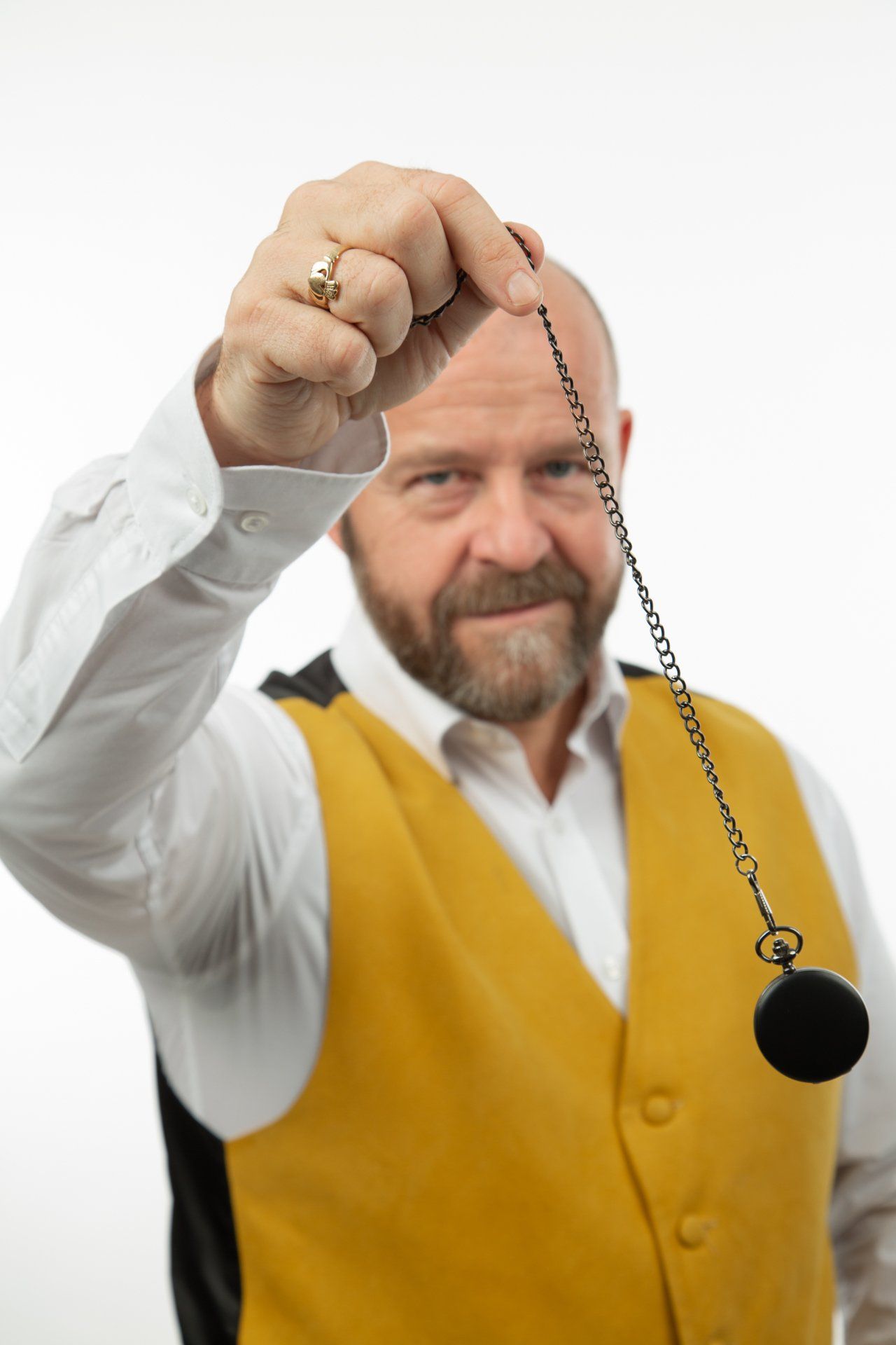 Emotipic of man wearing yellow waistcoat swinging a pocket watch taken in Leeds Photography Studio