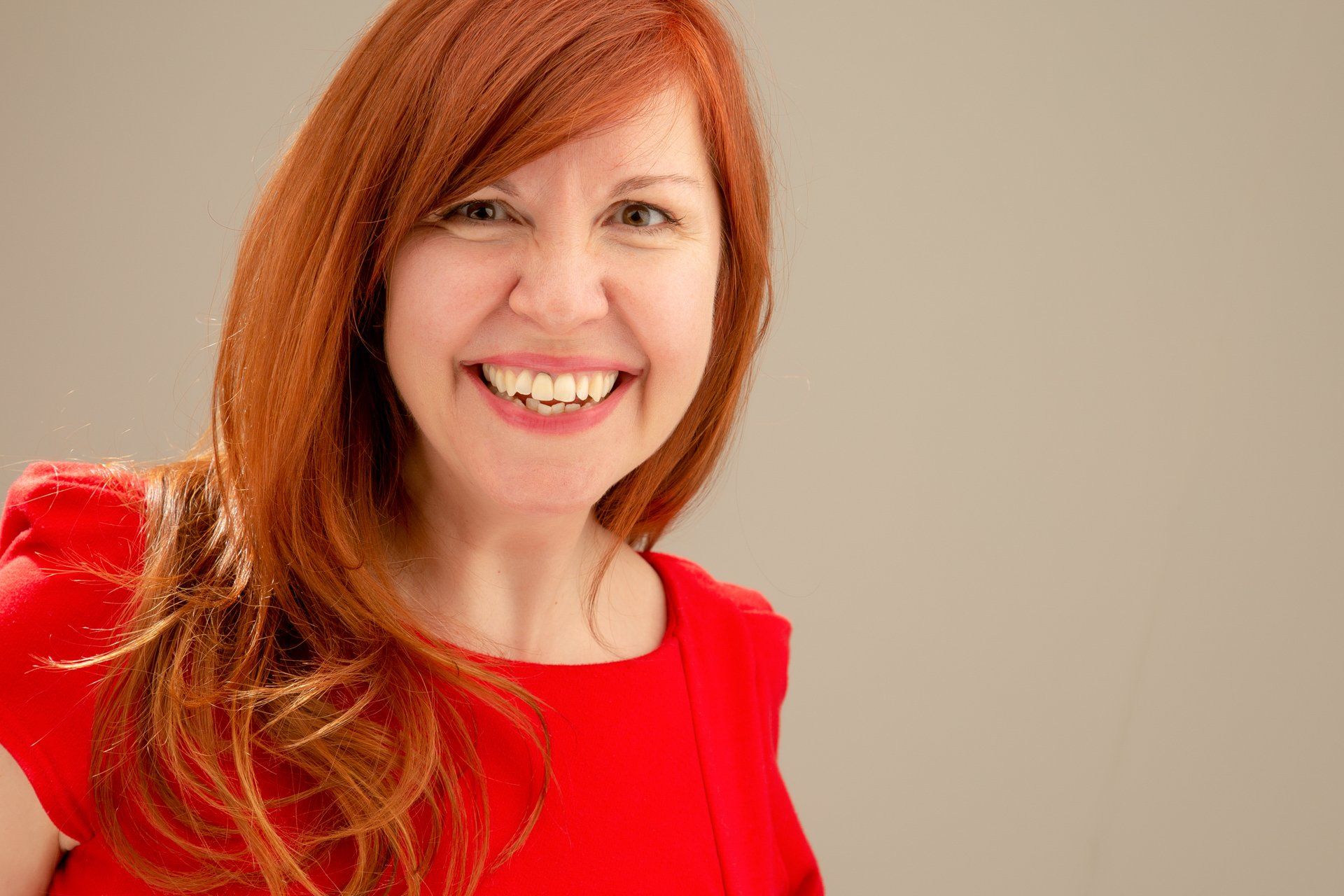 Headshot of lady wearing red dress taken at Roth Read Photography studio Leeds