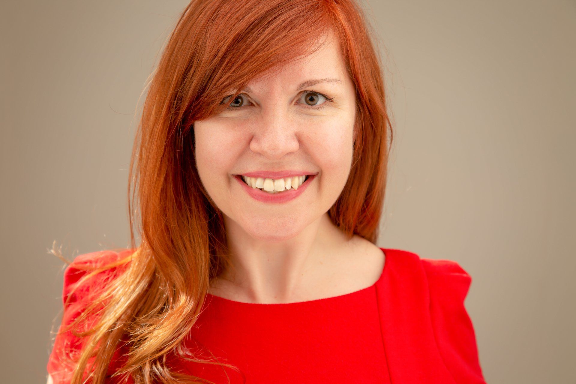 Headshot of lady wearing red dress taken at Roth Read Photography studio Leeds