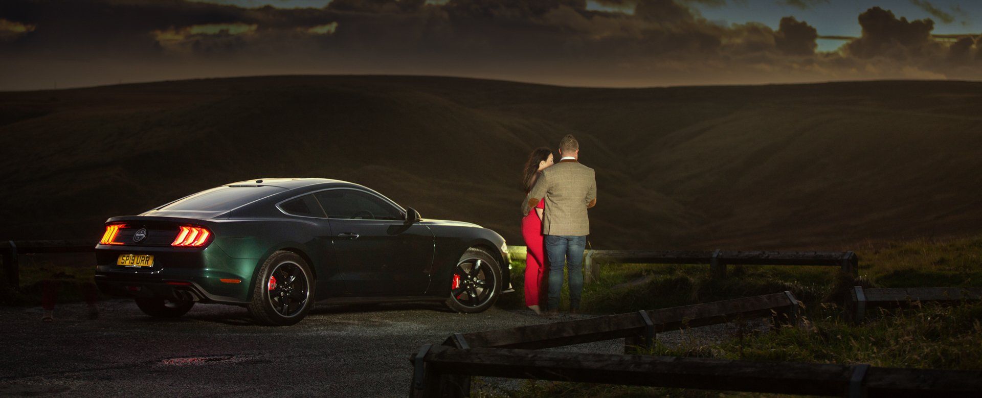 Couple with Mustang Bullitt 2020 looking out to Marston Moor, Huddersfield