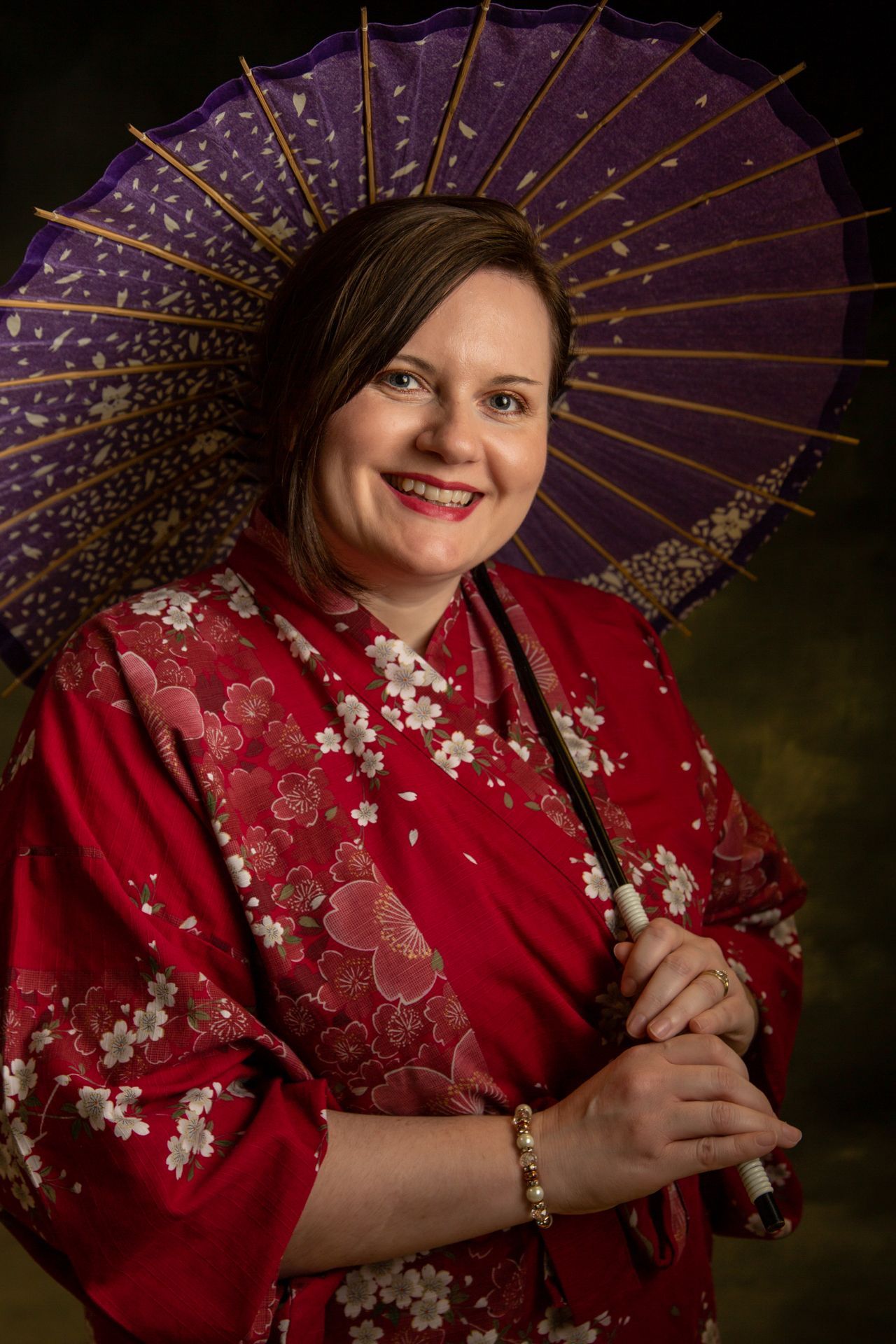 Lady wearing red kimono holding Japanese umbrella