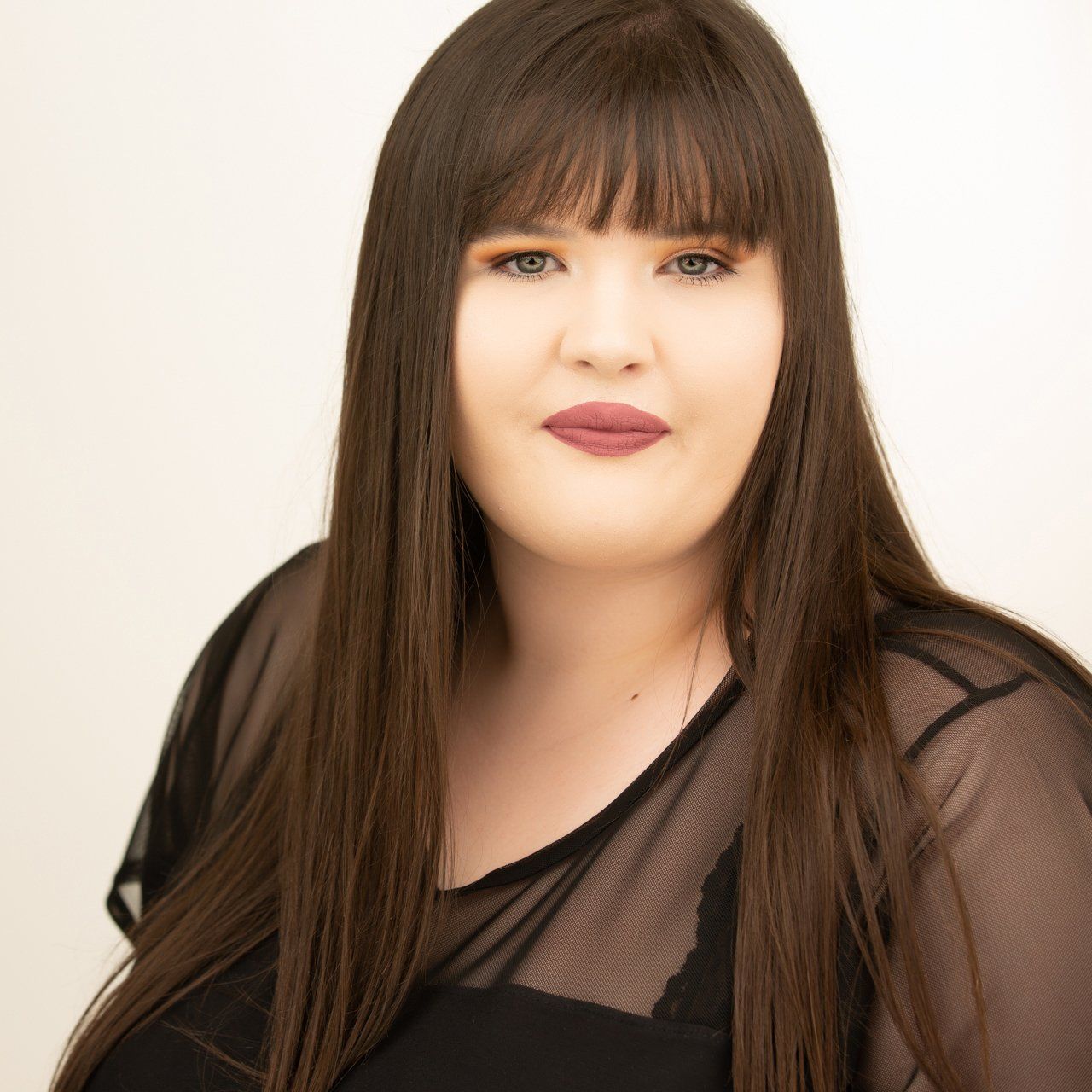 Headshot taken in Leeds photography studio of dark haired woman wearing black top.