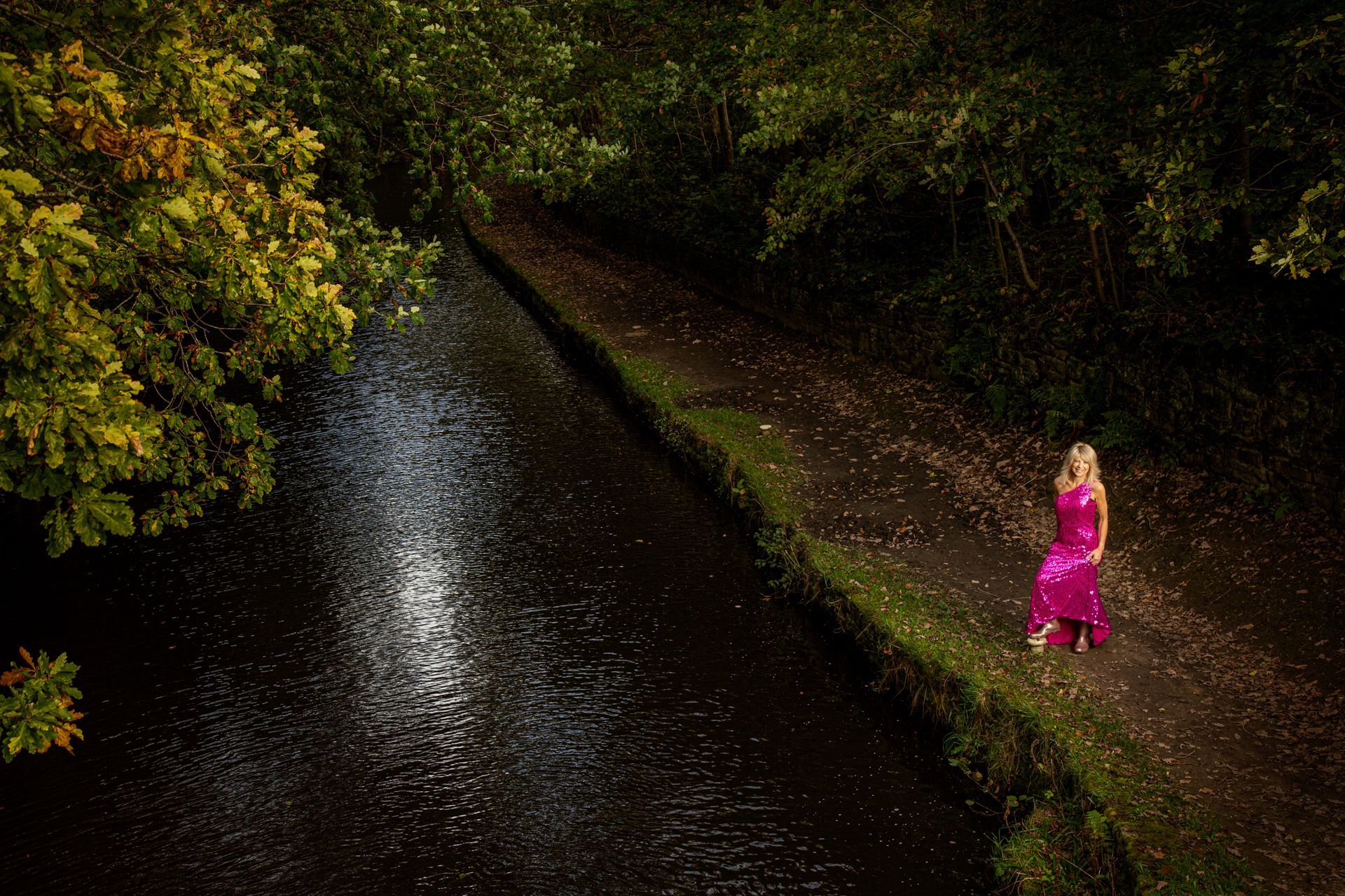 Mandy Taylor MBE wearing pink evening dress and sparkly wellies by canal