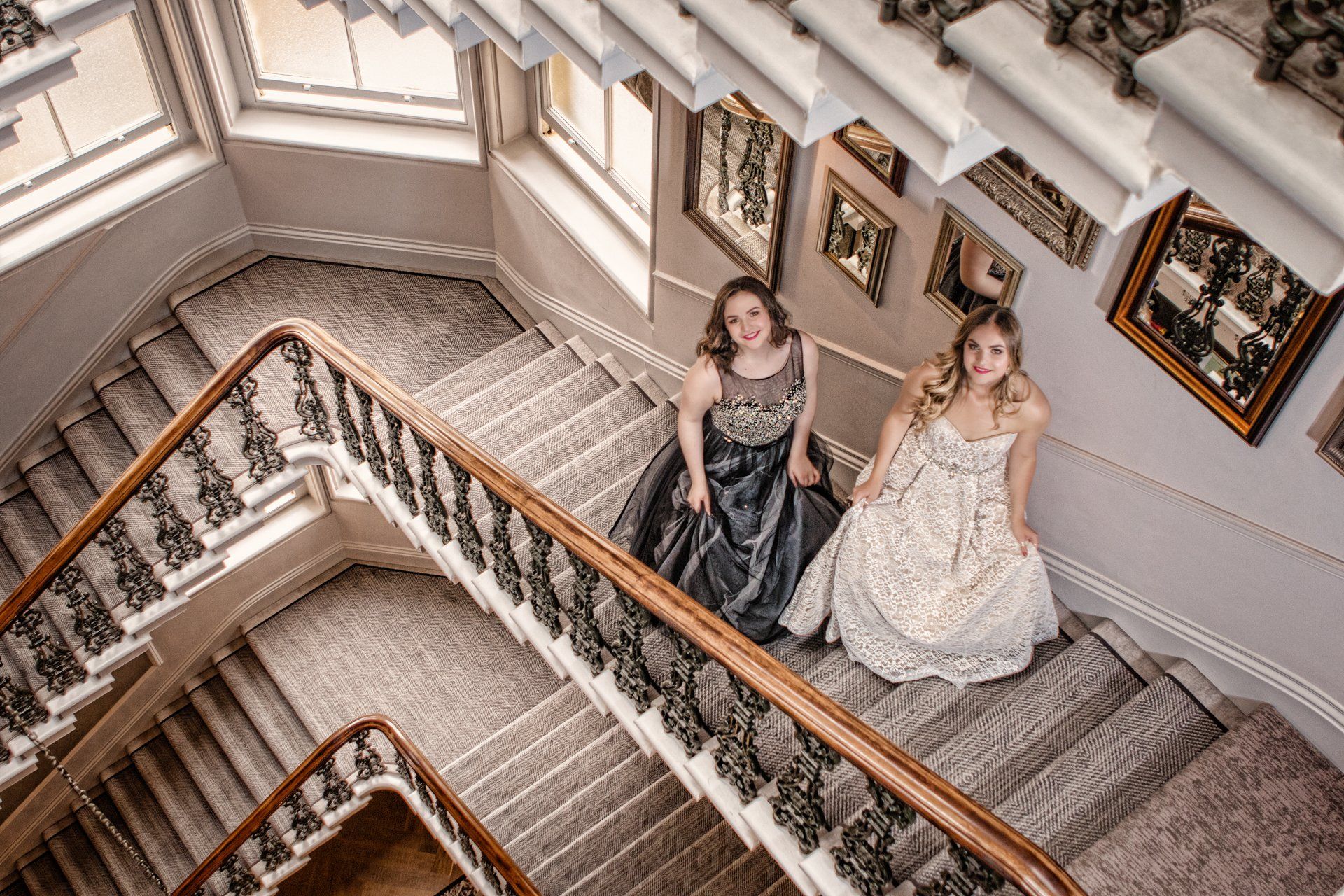 Sisters posed in stunning evening gowns on the staircase in The Principal Hotel, York