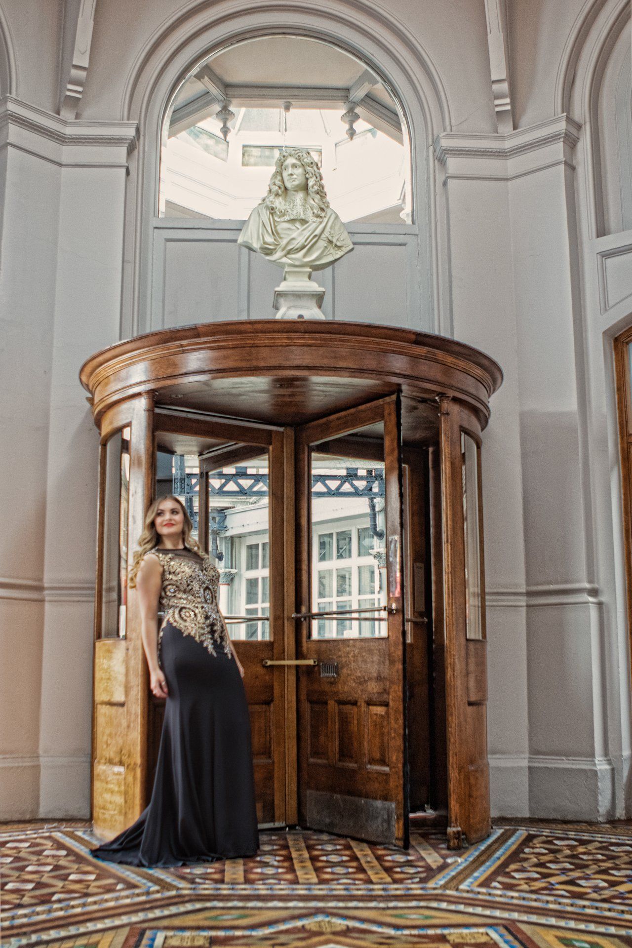 Young woman  in beautiful evening gown posing in the Victorian revolving door at The Principal Hotel, York